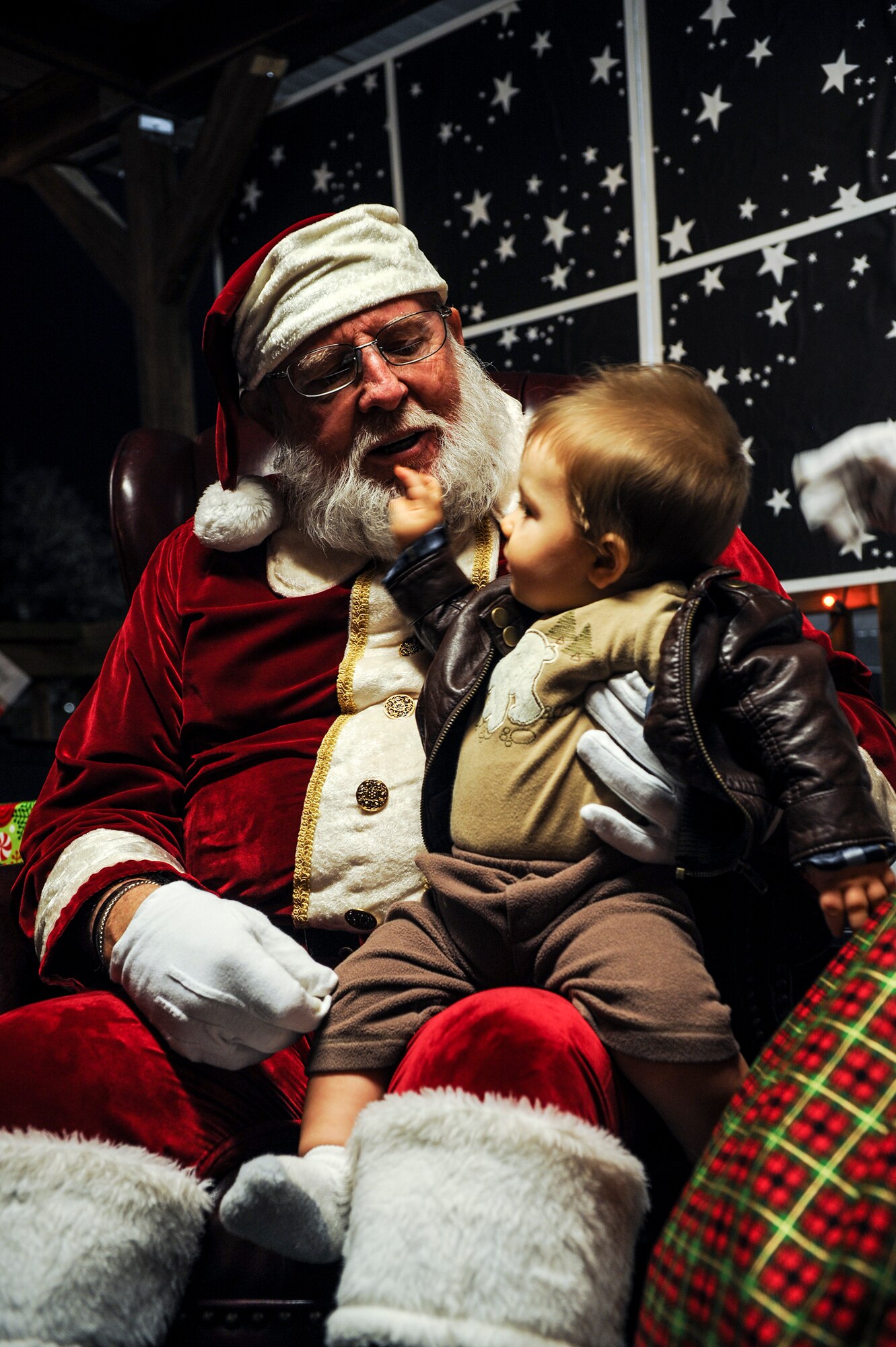 Owen, son of U.S. Air Force Airman 1st Class Elijah Chezem, 38th Rescue Squadron, sits on Santa’s lap, during the Annual Base Tree Lighting and Holiday Parade Dec. 5, 2014 at Moody Air Force Base, Ga. Besides pictures with Santa, the annual event included raffle give-a-ways, a parade, children’s activities and a tree lighting ceremony that honored deployed Airmen. (U.S. Air Force photo by Andrea Jenkins/Released)