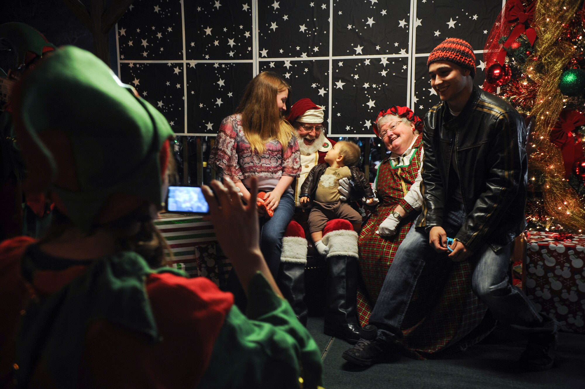 U.S. Air Force Airman 1st Class Elijah Chezem, 38th Rescue Squadron, and his family pose for a photo with Santa and Mrs. Claus at the annual Tree Lighting Ceremony, Dec. 5, 2014 at Moody Air Force Base, Ga. Attendees had the opportunity to meet Santa and give their holiday wishes. (U.S. Air Force photo by Andrea Jenkins/Released)