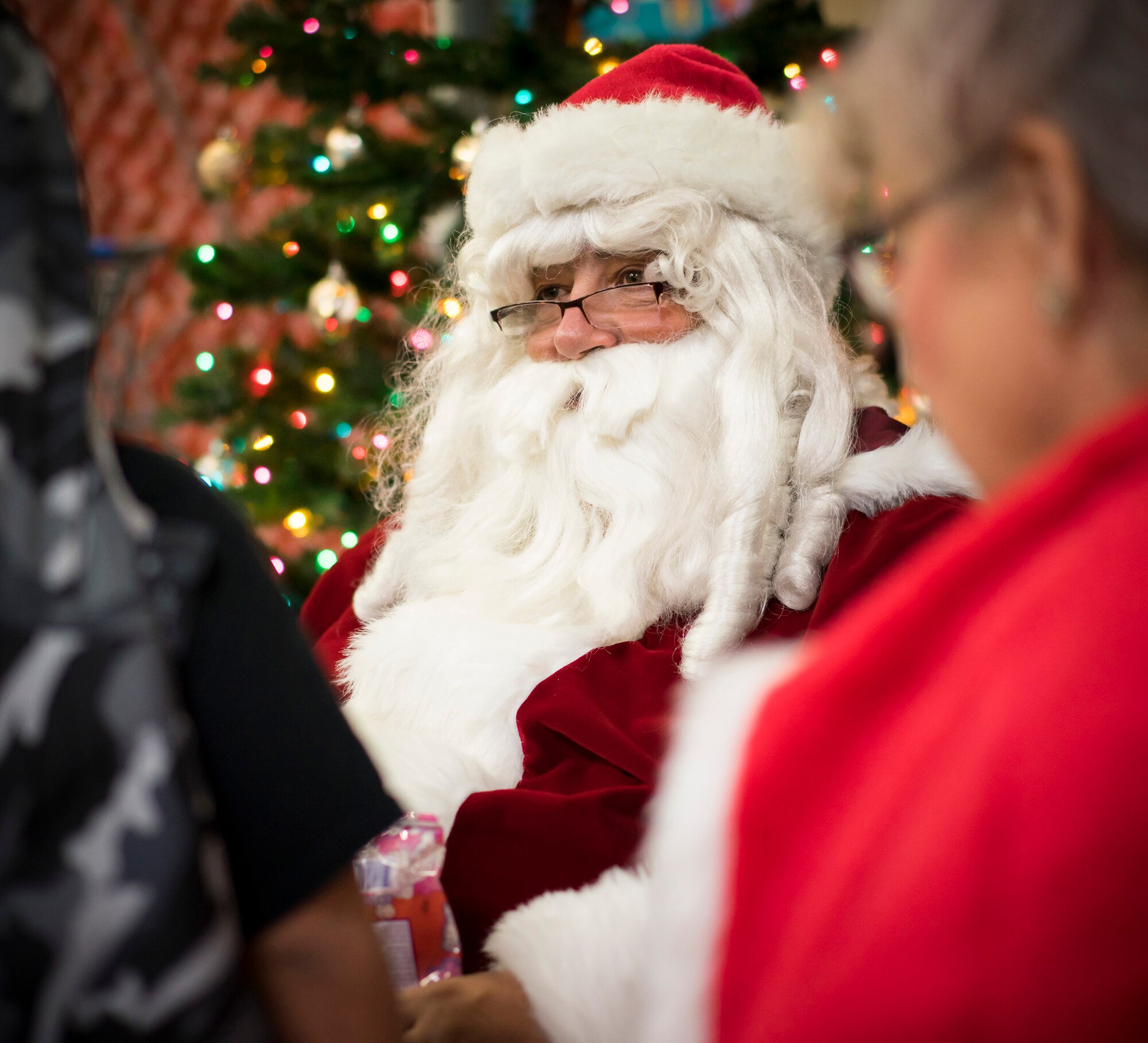 Santa smiles at children at Walmart in Mountain Home, Idaho, Dec. 6, 2014, during a "Shop with a Cop" event. After children selected and wrapped their gifts, they met Santa and received a candy cane and surprise gift. (U.S. Air Force photo/Tech. Sgt. Samuel Morse)