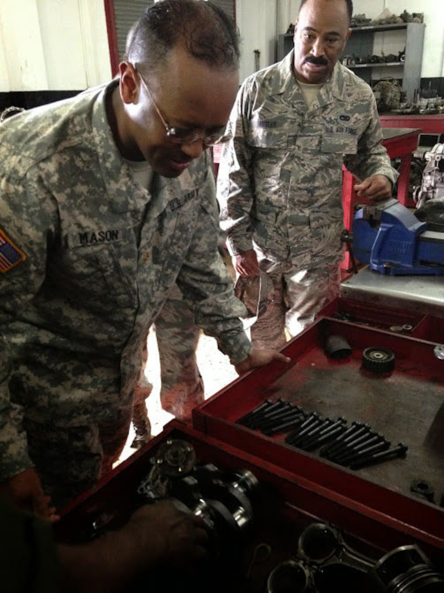 Maj. Baron Mason, D.C. National Guard Bilateral Affairs Officer, and Senior Airman Renardo Butler, vehicle mechanic of the 113th Wing, D.C. Air National Guard, examine vehicle parts during a tour of the Jamaica Defence Force’s vehicle maintenance operations at Up Park Camp. As part of the State Partnership Program, the D.C. National Guard team of Air Force and Army wheeled vehicle maintenance experts are working alongside their JDF counterparts to exchange information and learn from each other. (U.S. Air National Guard photo by Capt. Renee Lee)