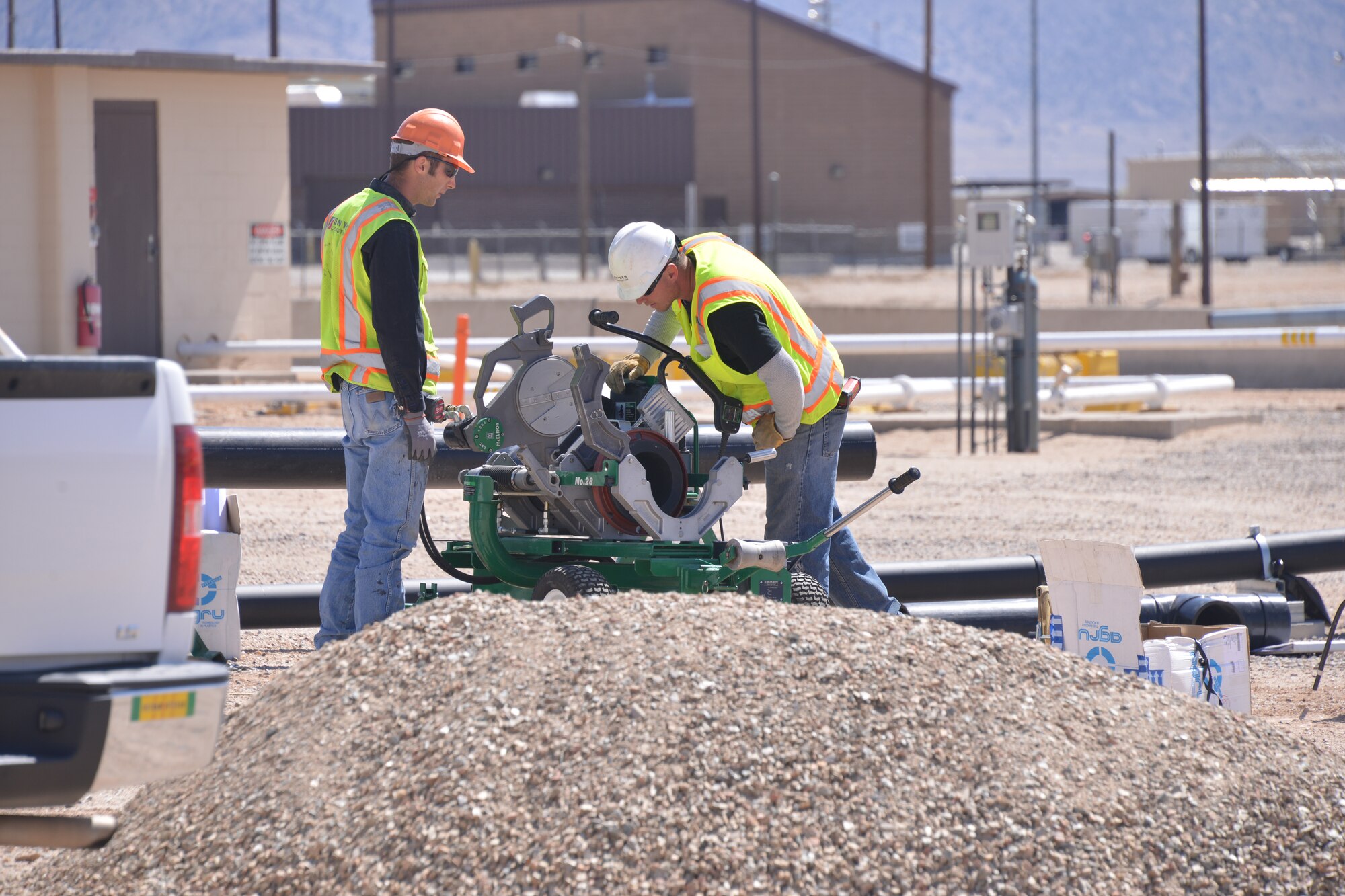 Crews lay a pipeline to connect a catalytic oxidizer to a well head at a fuel plume on Kirtland Air Force Base, New Mexico. A CATOX pulls contaminants from the soil and destroys them in a 1,000-degree converter. The work being done is part of a performance-based contract to remediate the fuel plume associated with a bulk fuel storage facility. Executed by the Air Force Civil Engineer Center, PBR contracts encourage innovation, save money and eliminate delays. (U.S. Air Force photo/Todd Berenger/Released)