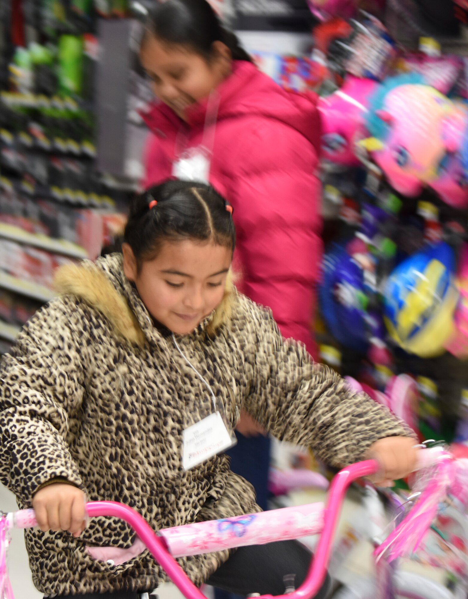 One of the children participating in the "Shop with a Cop" event test rides a bike before purchasing it in Mountain Home, Idaho, Dec. 6, 2014. Many of the volunteers agreed that the best part of the day was seeing the smiles on the children’s faces. (U.S. Air Force photo by Jeremy L. Mosier/RELEASED)