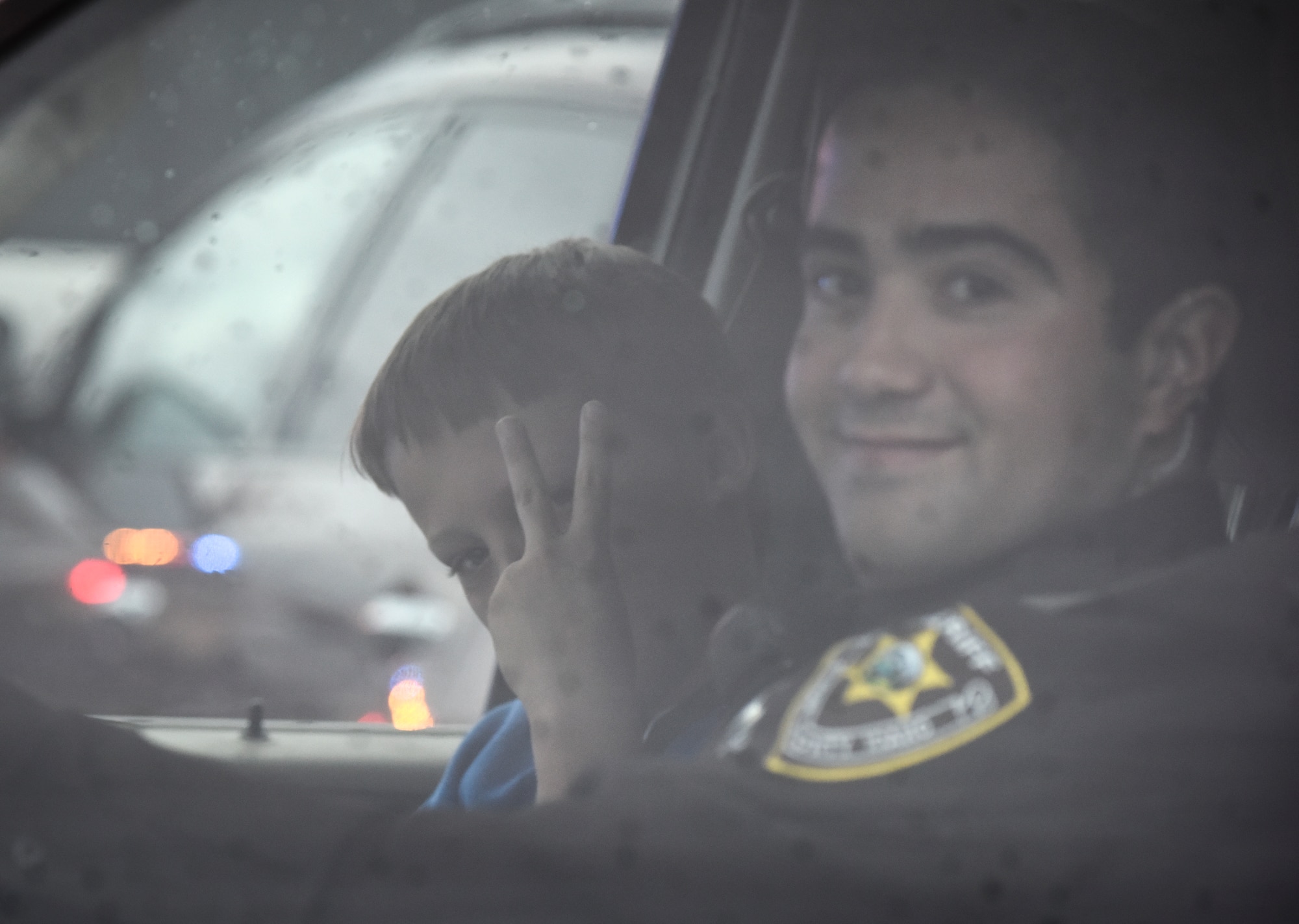 Mountain Home Deputy Varela escorts 10-year-old Daniel Johnson to the shopping portion of the "Shop with a Cop" event in Mountain Home, Idaho, Dec. 6, 2014. Law enforcement escorted the children through Mountain Home in a convoy stopping all traffic as they passed. (U.S. Air Force photo by Jeremy L. Mosier/RELEASED)