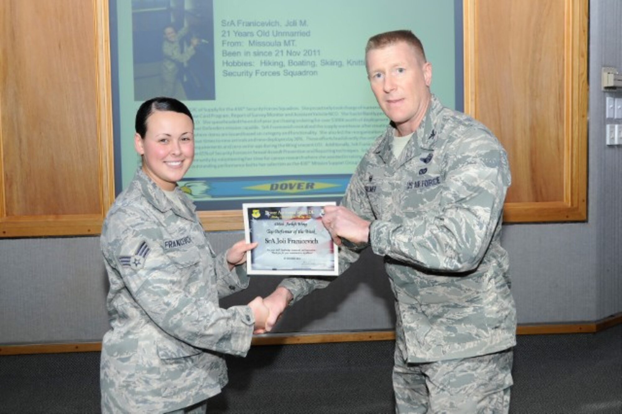 Col. Michael Grismer, 436th Airlift Wing commander, presents Senior Airman Joli Franicevich, 436th Security Forces Squadron supply custodian, with the Top Performer of the Week award Nov. 4, 2014, at Dover Air Force Base, Del. Franicevich also received the Air Mobility Command Outstanding Security Forces Support Staff Airman award. (U.S. Air Force photo/ Greg L. Davis)