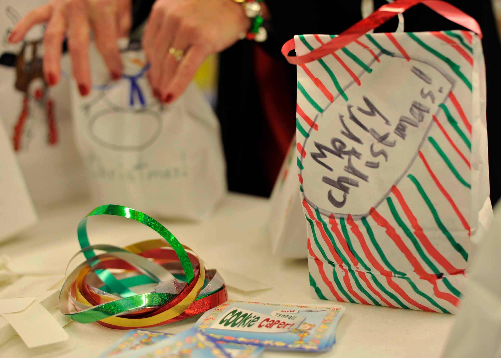 The Enlisted and Officer Spouses Clubs gathered more than 450 dozen cookies Dec. 8 at the base commissary to give out some holiday cheer to Airmen living in the dormitories. Tyndall Elementary School students provided bags with holiday and military decorations. (U.S. Air Force photo by Airman 1st Class Sergio A. Gamboa)