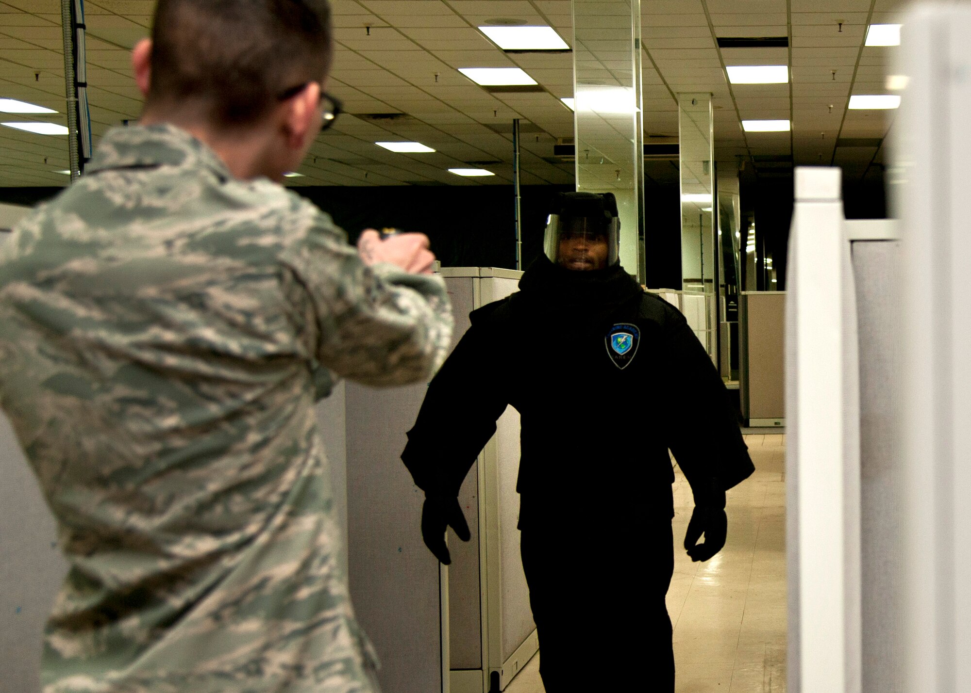 PETERSON AIR FORCE BASE, Colo. – Staff Sgt. Anthony Brodie, 21st Security Forces Squadron noncommissioned officer in charge unit trainer, charges at Airman 1st Class Earl Sanchez, 21st SFS alarm monitor, during the practical portion of a conductive electrical weapon, or taser, class, Nov. 19, 2014. The CEW is used as a secondary, non-lethal weapon and when used it delivers waves of electrical pulses causing neuromuscular incapacitation. (U.S. Air Force photo by Senior Airman Tiffany DeNault)