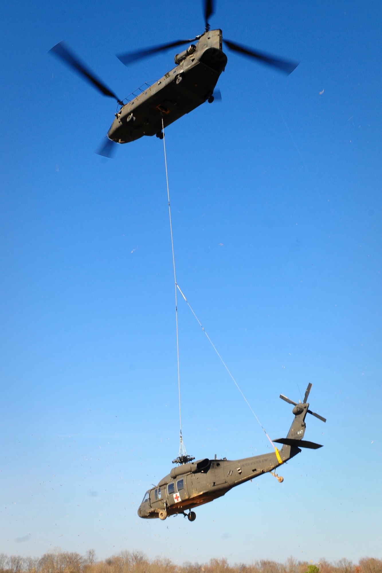 A U.S. Army CH-47 Chinook helicopter pilots assigned to 2-238th General Support Aviation Battalion, S.C. Army National Guard, sling-load a UH-60 Black Hawk helicopter from 1-171st General Support Aviation Battalion, S.C. Army National Guard. after the Black Hawk made an emergency landing in an open field Dec. 3, 2014, near Columbia, S.C., due to a main rotor blade malfunction. (U.S. Army photo by Sgt. Brian Calhoun)