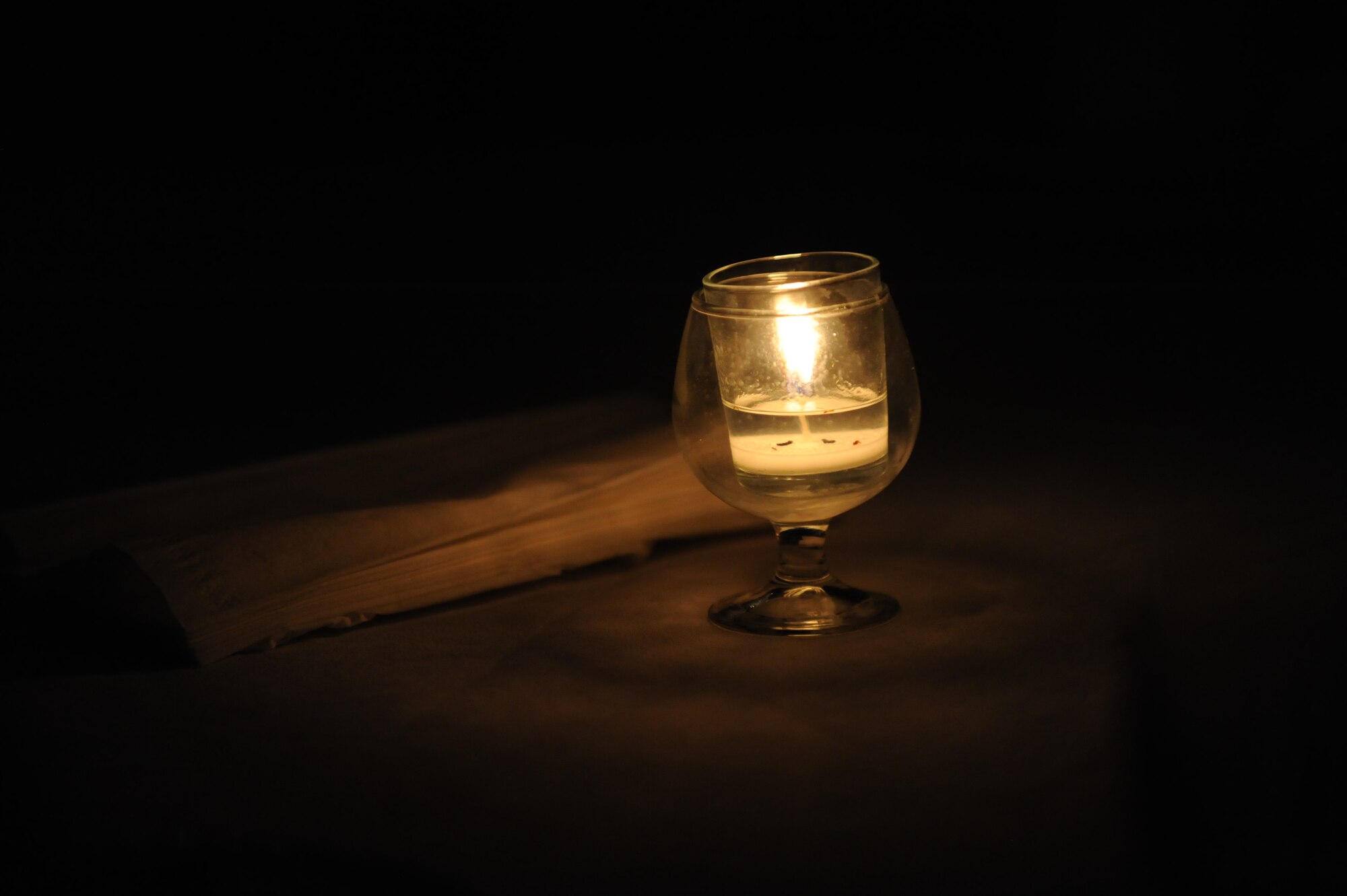 A solitary candle sits in the middle of a table at the Storytellers program on Minot Air Force Base, N.D., Dec. 5, 2014. Topics discussed at the first ever Minot session included tales of perseverance after sexual assault; how to seek help if one is contemplating suicide; and a wide array of avenues for those seeking assistance with difficult issues. (U.S. Air Force photo/Senior Airman Stephanie Morris)