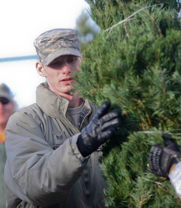 Staff Sgt. Christopher Wiedmer, 28th Logistics Readiness Squadron vehicle operator, unloads Christmas trees during a Trees for Troops delivery outside the 28th Force Support Squadron Outdoor Recreation Center at Ellsworth Air Force Base, S.D., Dec. 5, 2014. Wiedmer was among 20 volunteers who unloaded 175 trees donated by tree farmers from across the mid-west for military families. (U.S. Air Force photo by Senior Airman Zachary Hada/Released)