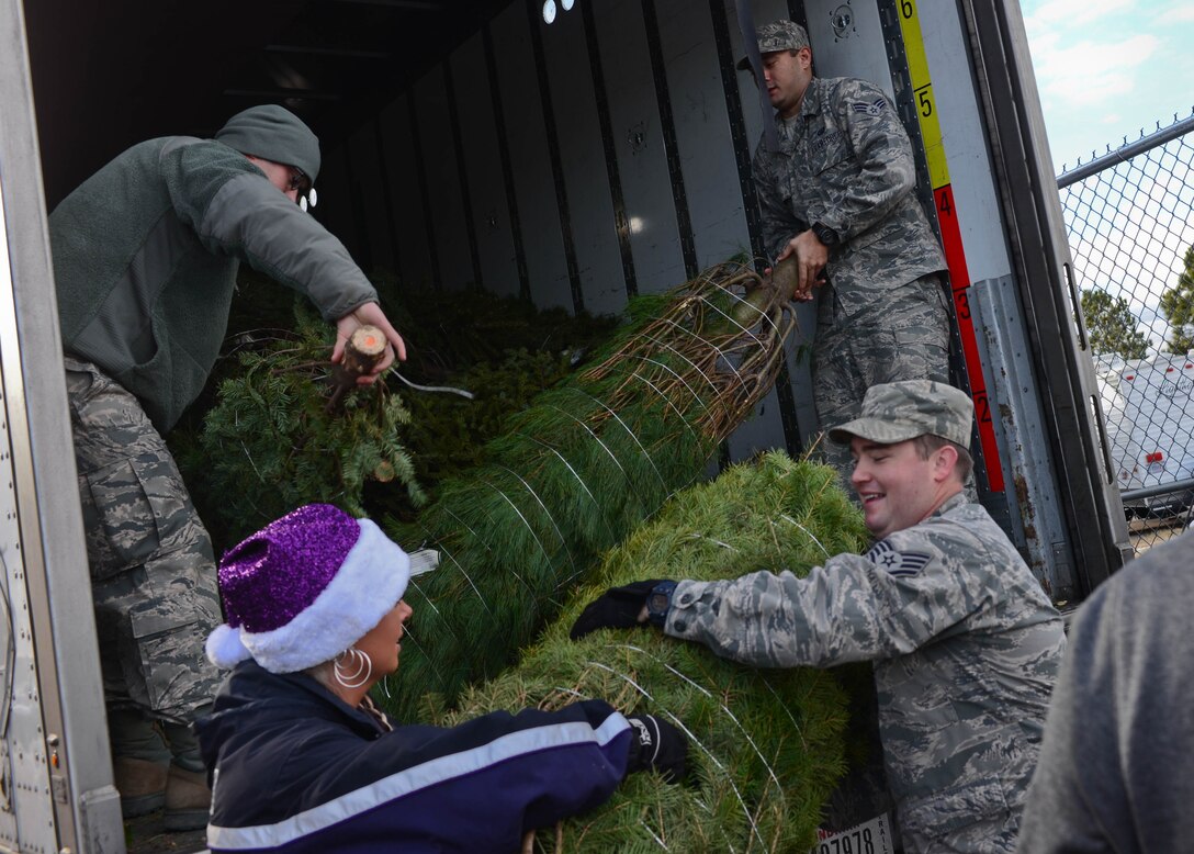Airmen and volunteers unload Christmas trees from a tractor trailer during a Trees for Troops delivery outside the 28th Force Support Squadron Outdoor Recreation Center at Ellsworth Air Force Base, S.D., Dec. 5, 2014. Spouses of deployed Airmen were given first pick of the trees available to all Ellsworth personnel, South Dakota National Guardsmen and Douglas High School Junior Reserve Officers Training Corps cadets. (U.S. Air Force photo by Senior Airman Zachary Hada/Released)