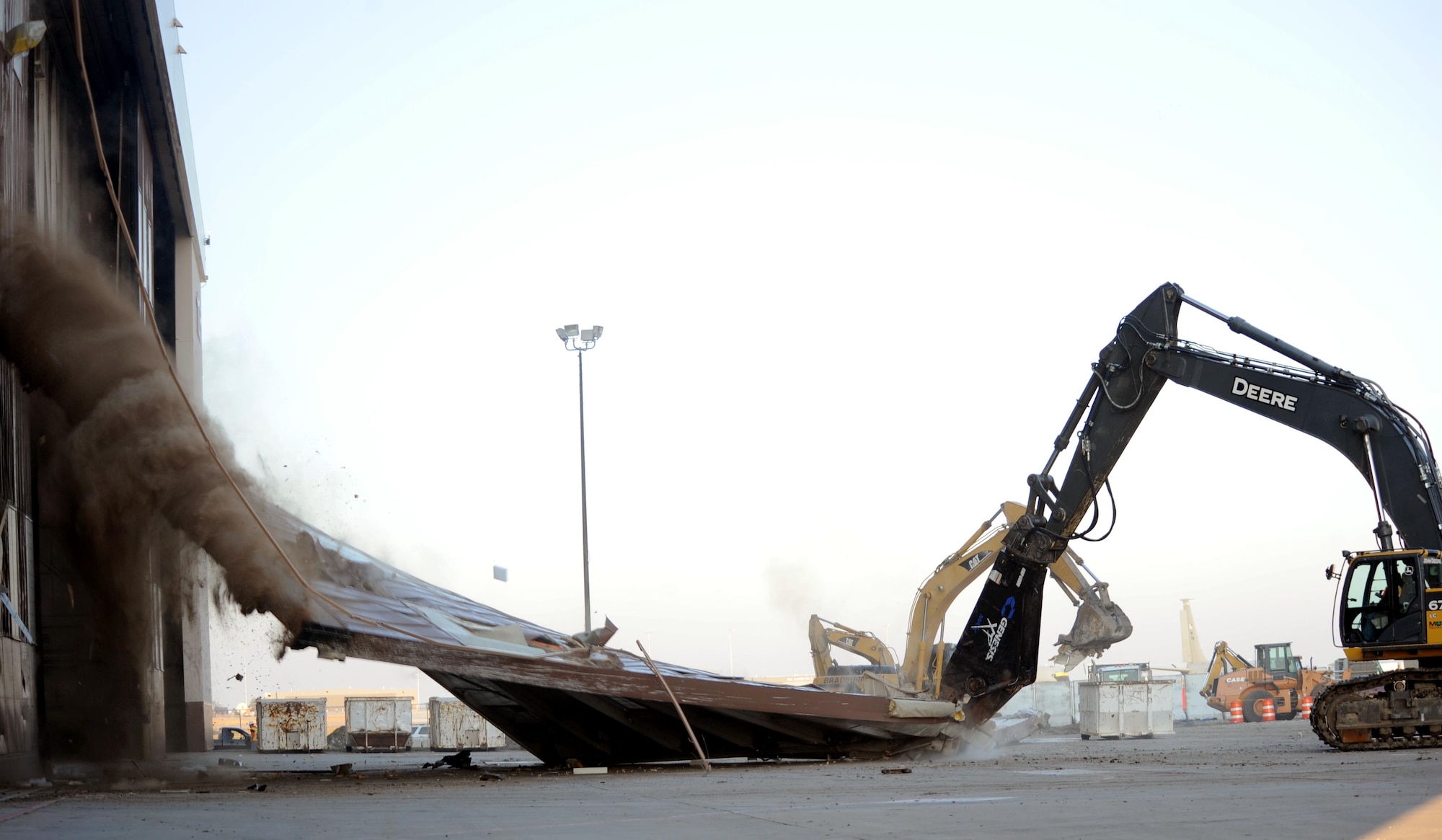 A hydraulic excavator tears down a hangar door as part of on-going construction work, Dec. 9, at McConnell Air Force Base, Kan. Hangar 1106 is being demolished to prepare for a three-bay hangar that is scheduled to be built for the incoming KC-46A Pegasus. The new hangar is scheduled to be completed by 2017. (U.S. Air Force photo/Airman 1st Class David Bernal Del Agua)