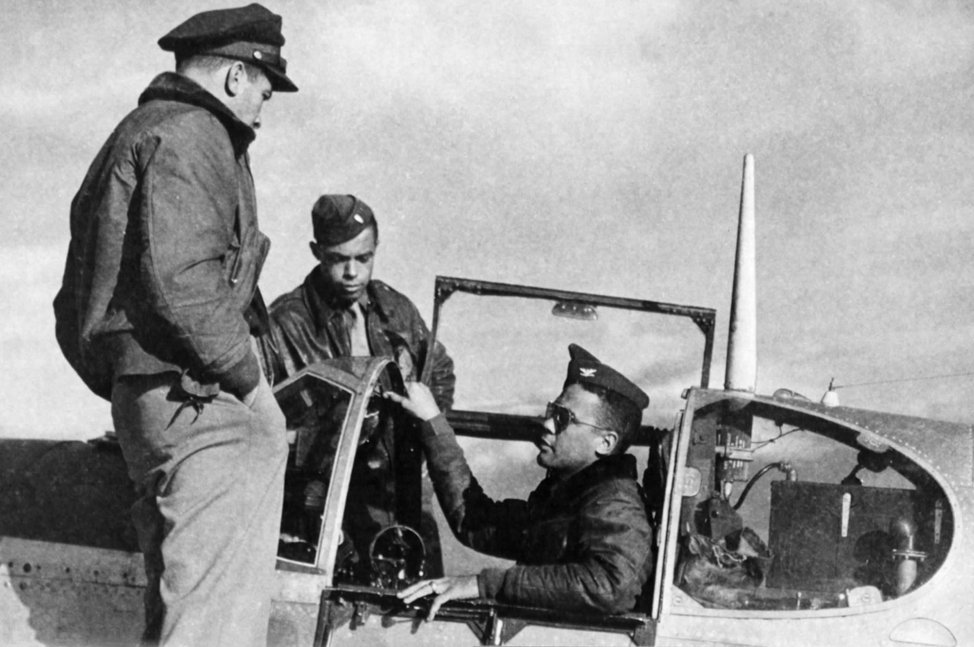 Col. Benjamin O. Davis Jr. discusses a just completed strafing mission with two of his pilots. (U.S. Air Force photo)