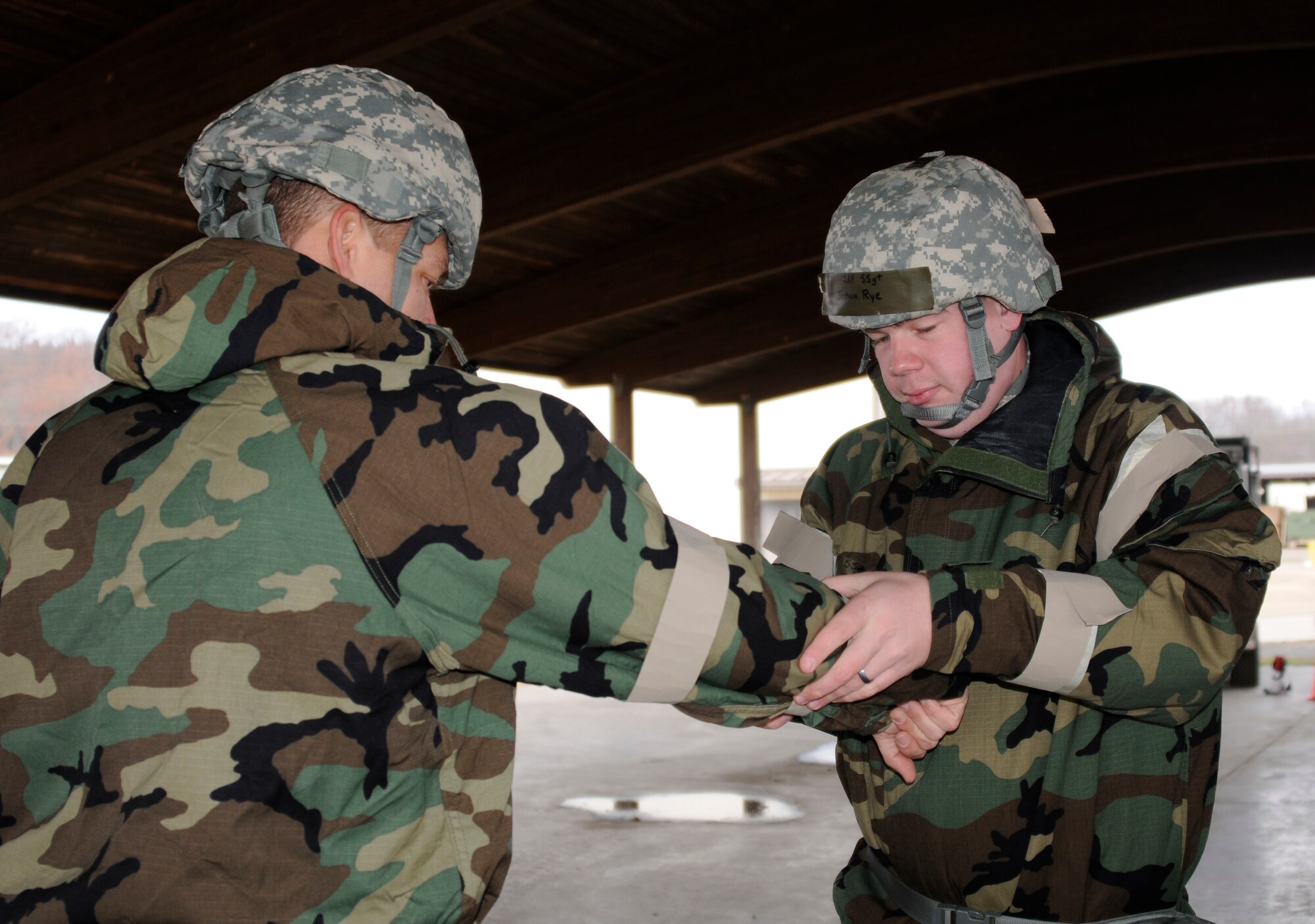 Staff Sgt. Joshua Rye applies M-9 chemical agent detection paper tape to an Airman’s mission oriented protective posture gear during an expeditionary skills rodeo at Ebbing Air National Guard Base Fort Smith, Ark., Dec. 7, 2014. An ESR will be conducted quarterly to ensure Airmen maintain current on self-aid and buddy care training and chemical, biological, radiological and nuclear training. Rye is assigned to the 188th Civil Engineer Squadron. (U.S. Air National Guard photo by Staff Sgt. Hannah Dickerson/Released)