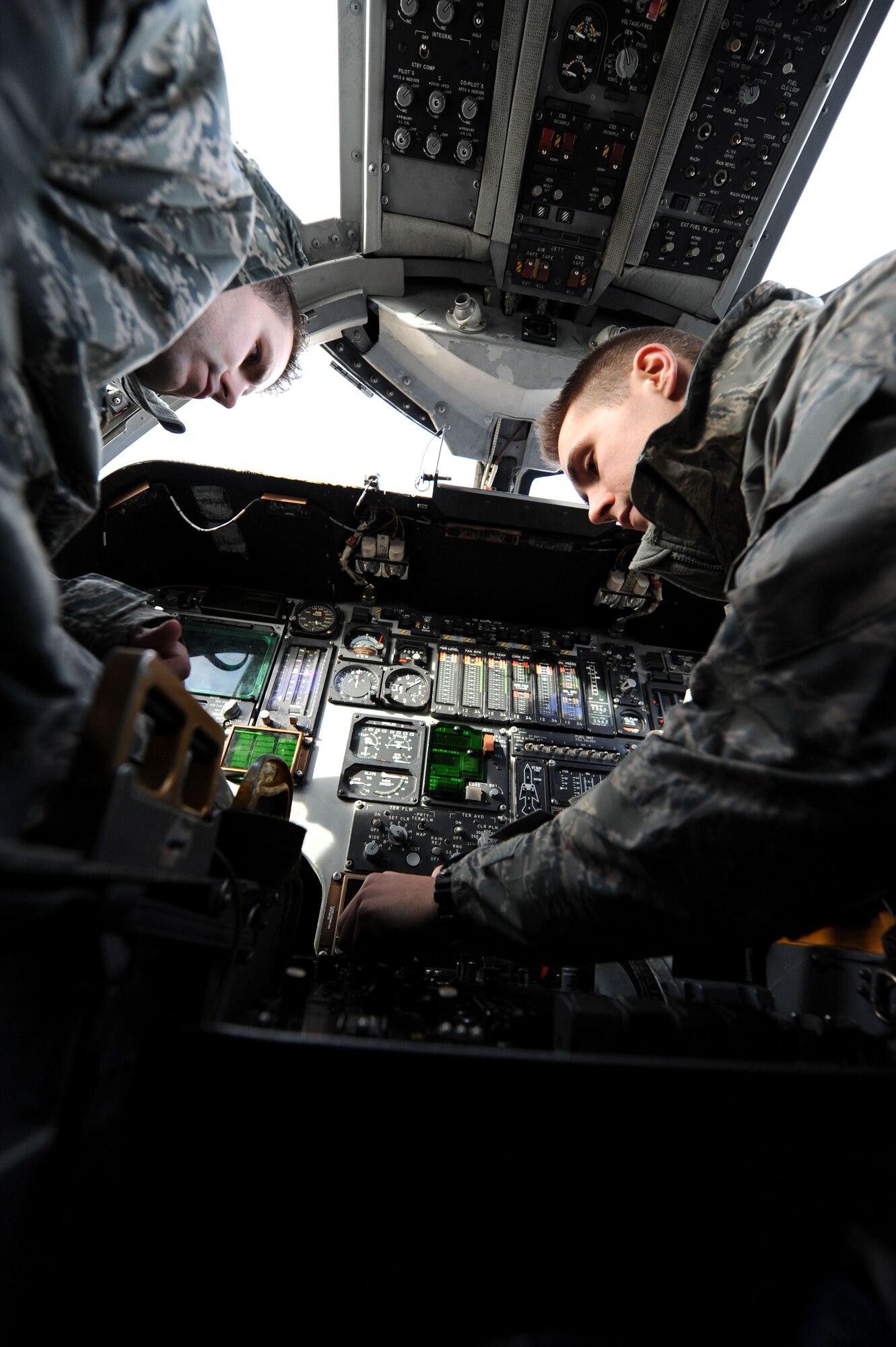 Senior Airman James Earnst (right), 37th Aircraft Maintenance Unit communication, navigation and mission systems journeyman, unscrews the control panel of a radar altimeter in a B-1 bomber while being supervised by Staff Sgt. Tim Burgett (left), 37th AMU communication, navigation and mission systems craftsman, during regular maintenance at Ellsworth Air Force, Base, S.D., Dec. 3, 2014. The radar altimeter provides a digital readout of an aircraft’s altitude combined with a discrete warning indicator which alerts the pilot when the aircraft drops below a pre-selected altitude. (U.S. Air Force photo by Senior Airman Hailey R. Staker/Released)