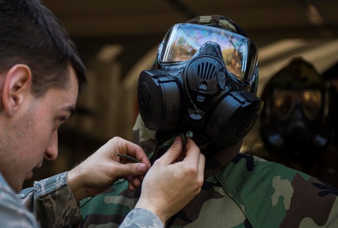 Airman 1st Class Gregory Emond, 628th Civil Engineer Squadron emergency management apprentice, checks an Airman's chemical suit during a chemical, biological, radiological, nuclear and high-yield explosives training course Dec. 3, 2014, at Joint Base Charleston, S.C. After Air Force Basic military training, active-duty Airmen are required to go through CBRNE refresher training every two years. (U.S. Air Force photo/Senior Airman Marianique Santos)