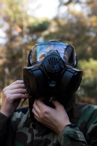 Airman 1st Class Dana Horn, 628th Air Base Wing command post controller, fastens the nape of her chemical suit during a chemical, biological, radiological, nuclear and high-yield explosives training course Dec. 3, 2014, at Joint Base Charleston, S.C. After Air Force Basic military training, active-duty Airmen are required to go through CBRNE refresher training every two years. (U.S. Air Force photo/Senior Airman Marianique Santos)