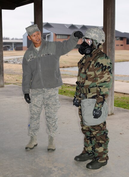 Master Sgt. Robby McGee explains the areas that need to be inspected, with a buddy check, on Senior Airman Samantha Morse’s mission oriented protective posture during an expeditionary skills rodeo at Ebbing Air National Guard Base Fort Smith, Ark., Dec. 7, 2014. An ESR will be conducted quarterly to ensure Airmen maintain current on self-aid and buddy care training and chemical, biological, radiological and nuclear training. McGee is assigned to the 188th Civil Engineer Squadron and Morse is assigned to the 223rd Intelligence Support Squadron. (U.S. Air National Guard photo by Staff Sgt. Hannah Dickerson/Released)