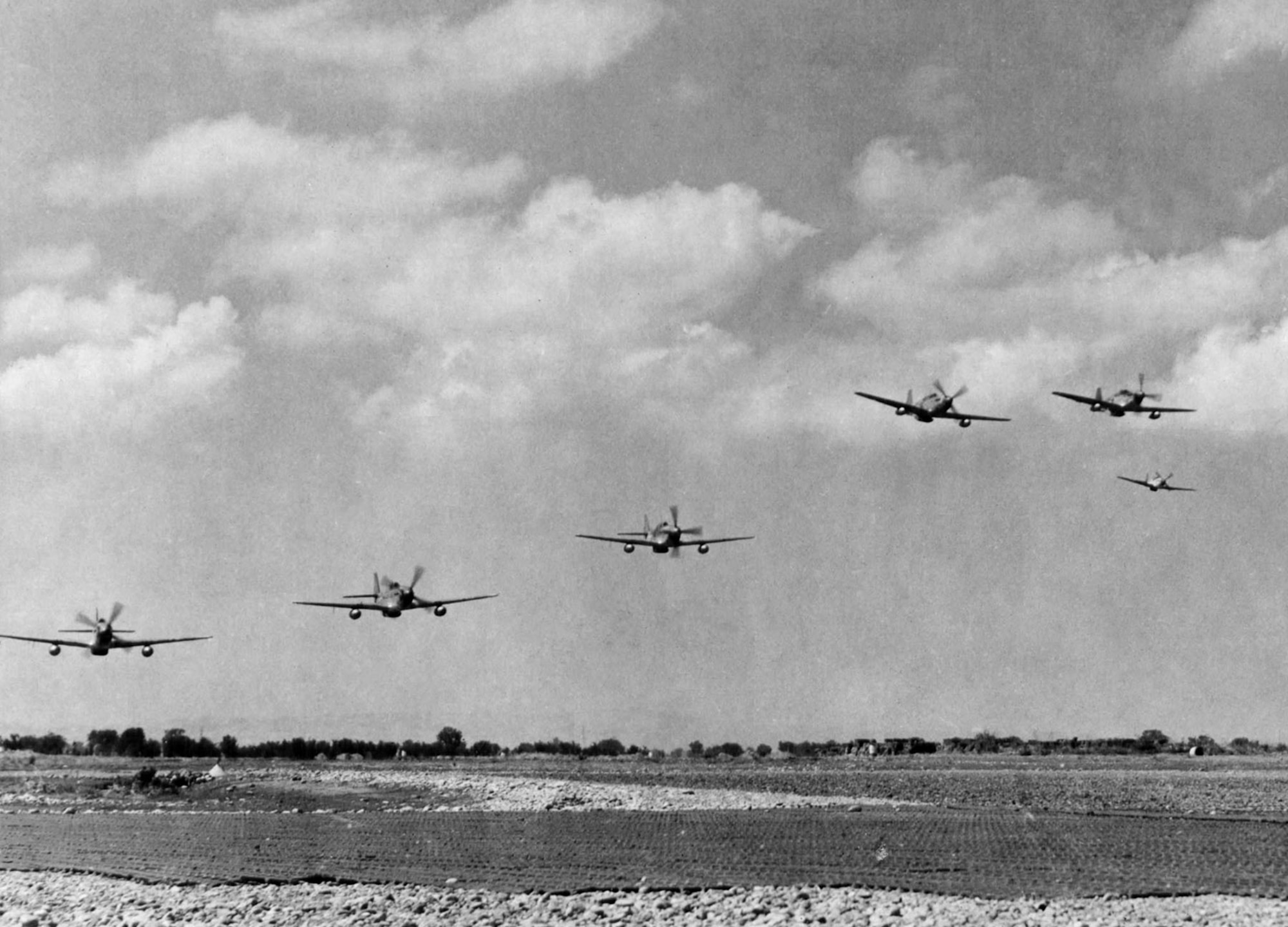 Red Tails of the 332nd Fighter Group take off to escort heavy bombers sent to bomb enemy oil fields at Blechhammer, Germany, on Aug. 7, 1944. Note the P-51s have wing tanks for the extra fuel needed for such long missions. (U.S. Air Force photo)