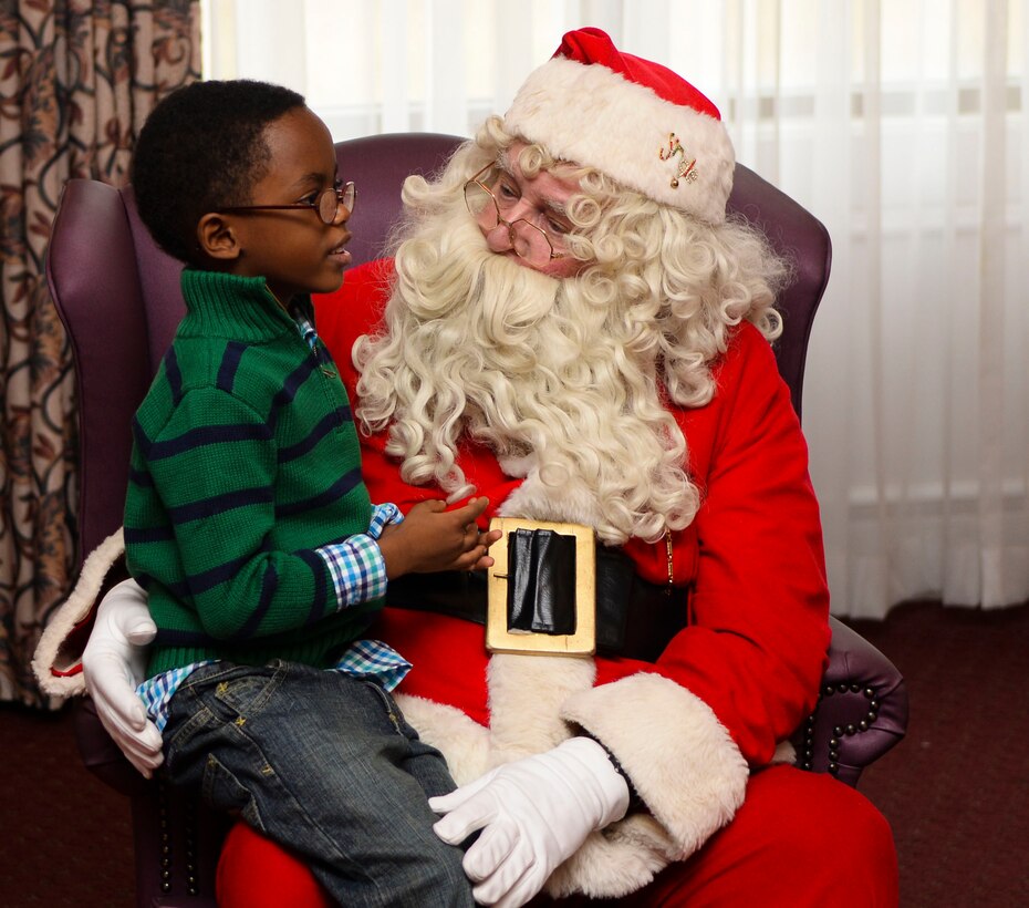 Kenyan Hines, son of U.S. Army Staff Sgt. Josilyn Hines, Army Training Support Center instructor, tells Santa Claus what he wants for Christmas during Breakfast with Santa at Fort Eustis, Va., Dec. 6, 2014. After talking with Santa, children received a bag of goodies from Mrs. Clause. (U.S. Air Force photo by Senior Airman Austin Harvill/Released)