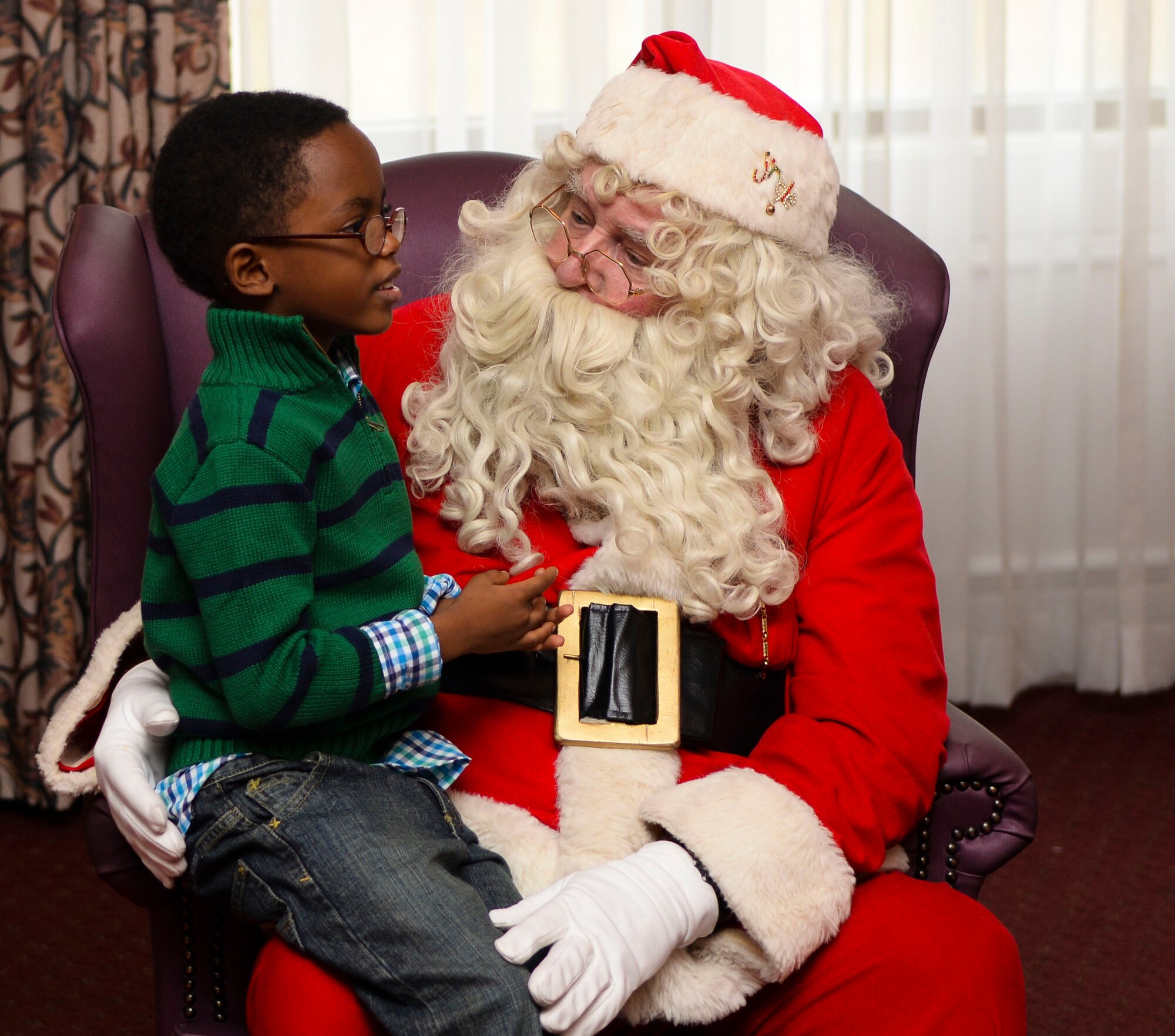 Kenyan Hines, son of U.S. Army Staff Sgt. Josilyn Hines, Army Training Support Center instructor, tells Santa Claus what he wants for Christmas during Breakfast with Santa at Fort Eustis, Va., Dec. 6, 2014. After talking with Santa, children received a bag of goodies from Mrs. Clause. (U.S. Air Force photo by Senior Airman Austin Harvill/Released)