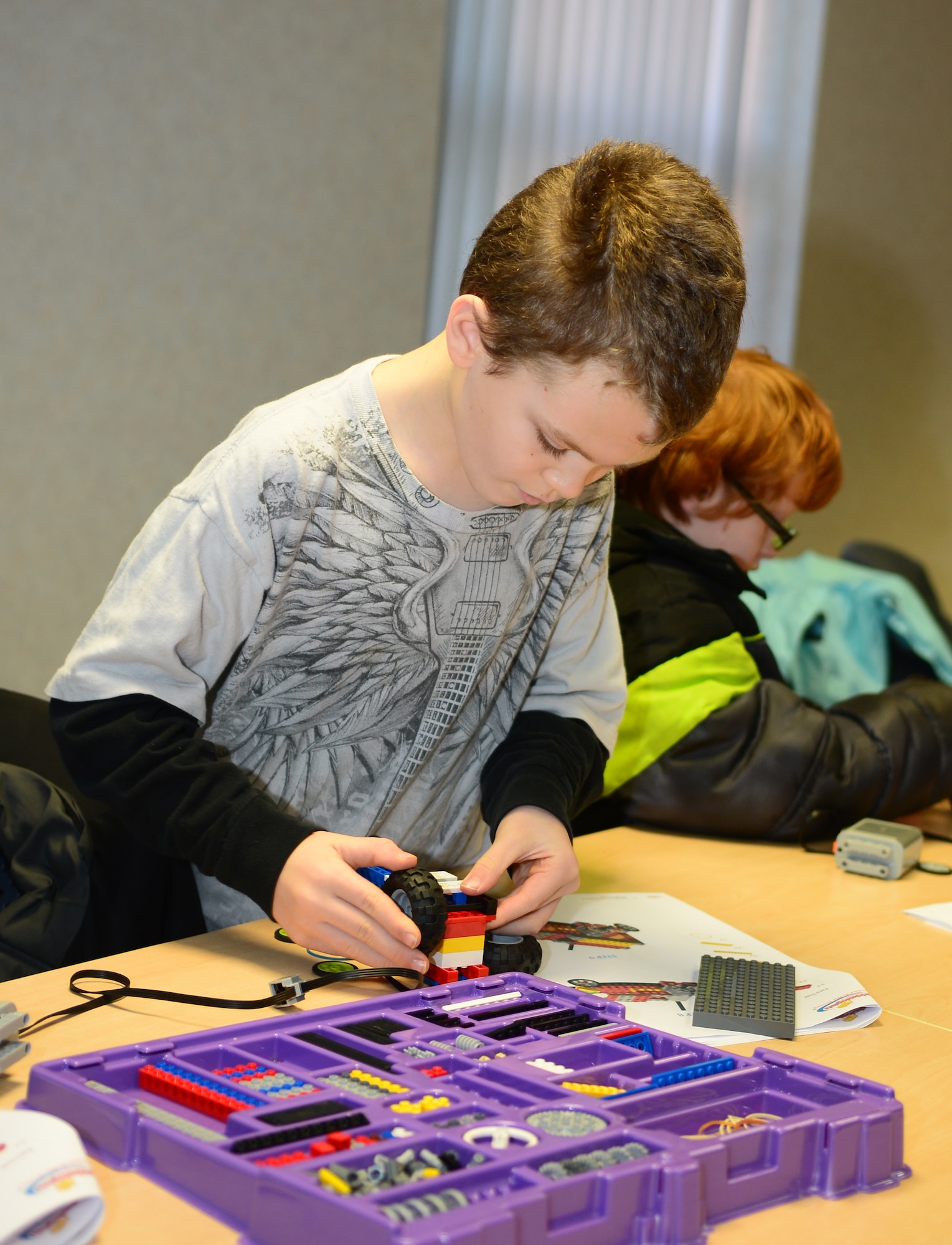 Cameron Vogel, son of U.S. Air Force Master Sgt. Michael Vogel, 100th Logistic Readiness Squadron unit deployment manager from Baltimore, builds a miniature motorized vehicle with building blocks at the Young Engineer Camp Dec. 6, 2014, at the Airman and Family Readiness Center on RAF Mildenhall, England. The camp was designed to give RAF Mildenhall’s exceptional family members a friendly learning environment with peers of similar interest. (U.S. Air Force photo by Airman 1st Class Jonathan Light/Released)