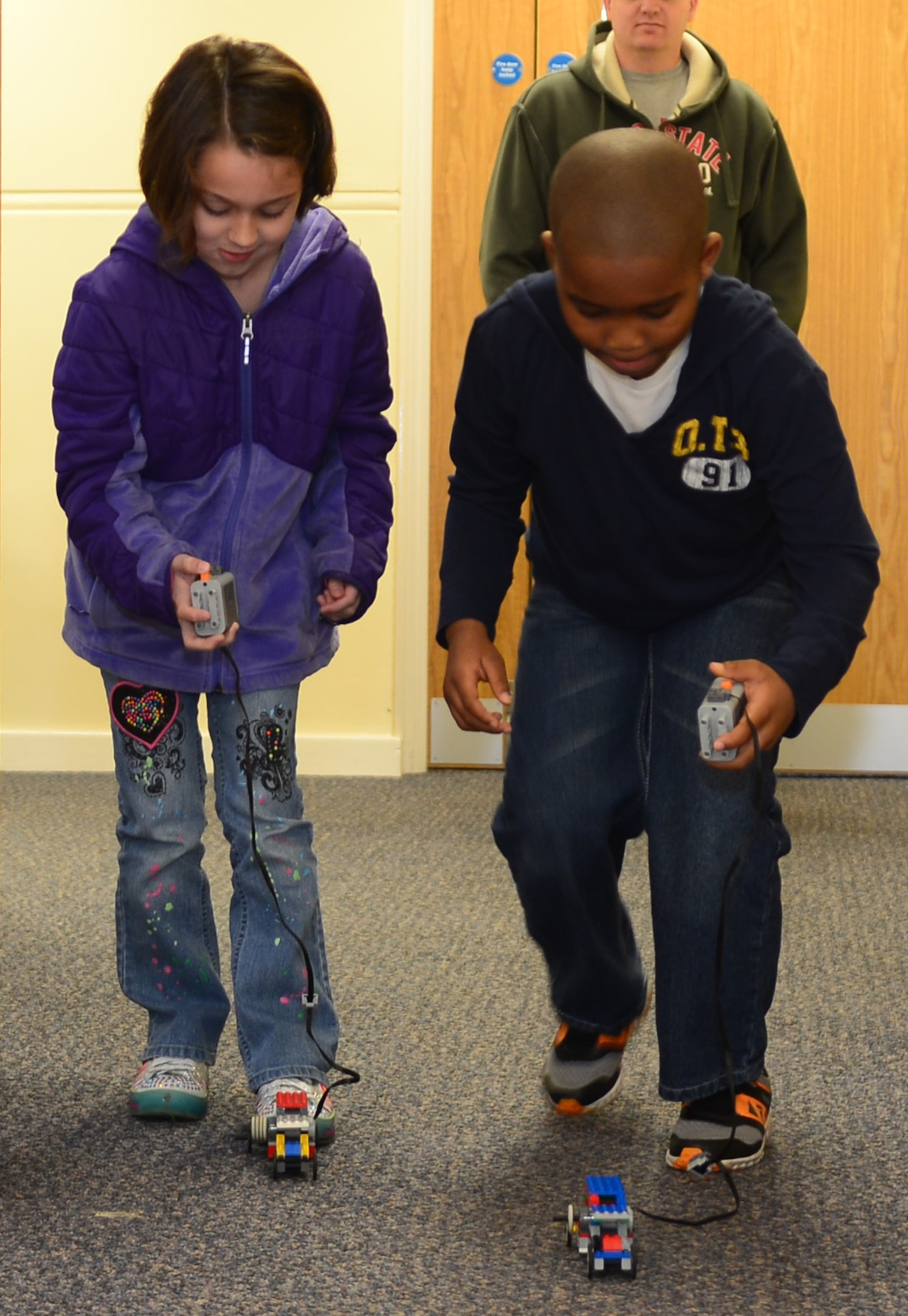 Chloe Wikoff, left, daughter of U.S. Air Force Tech. Sgt. Andrew Wikoff, 100th Air Refueling Wing Judge Advocate NCO in charge from Carroll, Ohio, races miniature motorized vehicles with Lucas Tyler, son of U.S. Air Force Lt. Col. Aquilla Tyler, 48th Medical Group women’s health clinic medical director from Clinton, N.C., during the Young Engineer Camp Dec. 6, 2014, at the Airman and Family Readiness Center on RAF Mildenhall, England.  The camp was designed to give RAF Mildenhall’s exceptional family members a friendly learning environment with peers of similar interest. (U.S. Air Force photo by Airman 1st Class Jonathan Light/Released)