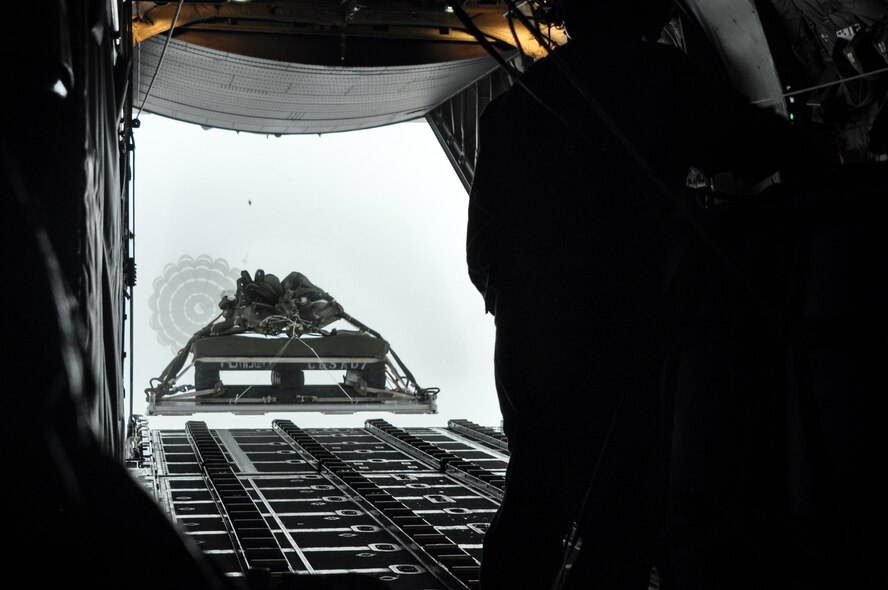 Technical Sgt. Richard Signorelli, 758th Airlift Squadron loadmaster, watches as a heavy cargo pallet drops out of the back of a C-130 Hercules at the Cadiz, Ohio drop zone Dec. 6th, 2014. The heavy pallet will be retrieved by members of the 32nd Aerial Port Squadron on the ground; the same squadron that built the pallet before it was loaded onto the C-130. (U.S. Air Force photo by Senior Airman Justyne Obeldobel)