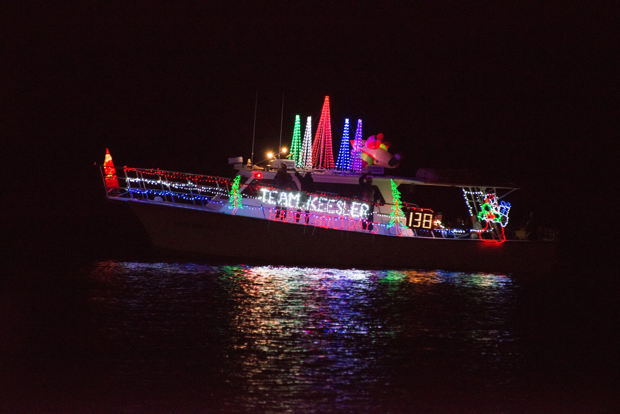 The Keesler Dolphin passes the judging boat during the 29th annual Christmas on the Water parade in Biloxi, Miss. Dec. 6, 2014. The boats, which parade along the gulf coast in full holiday décor, are judged by originality of theme, complexity of design, and overall appearance.  Brig. Gen. Patrick Higby, 81st Training Wing commander, and his wife; Col. Dennis Scarborough, 81st TRW vice commander, and Maj. Carla Gleason, 81st TRW Public Affairs officer, were judges for the event.  (U.S. Air Force photo by Marie Floyd)