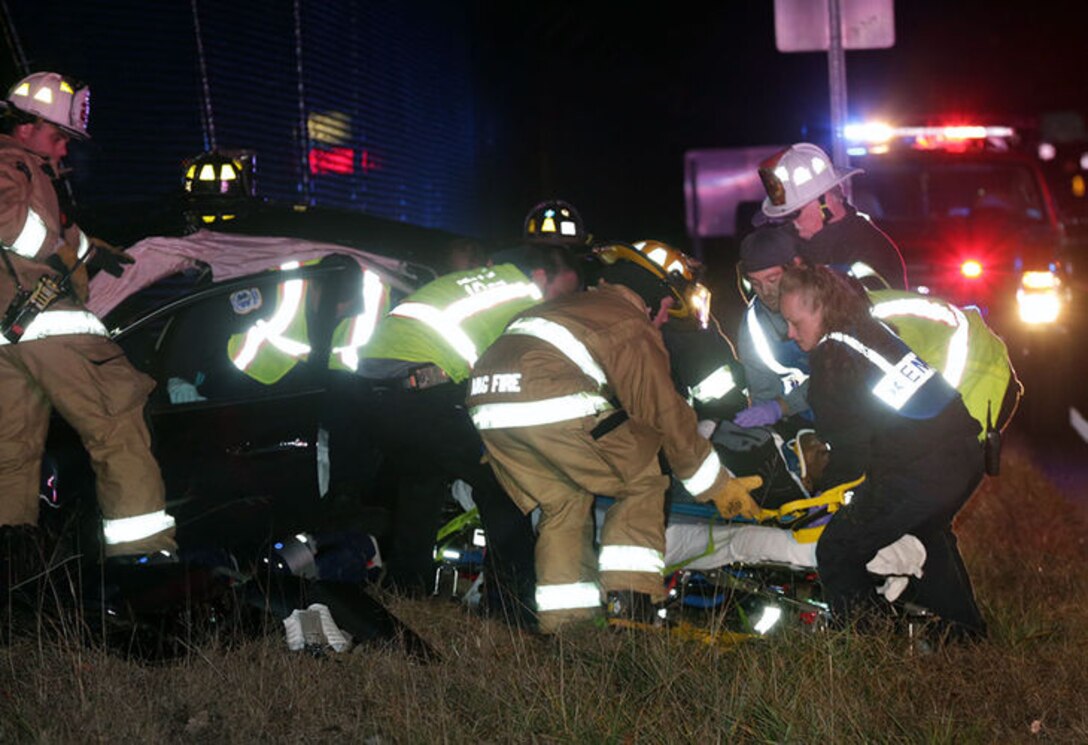 U.S. Air Force Airmen from the 177th Fighter Wing Fire Department as well as local first responders extract a car crash victim and place him on a stretcher on Dec. 4, 2014 in Egg Harbor Township, N.J. The vehicle was involved in a head-on collision, and crashed into the airport fence. (Courtesy photo, Michael Ein, Press of Atlantic City)