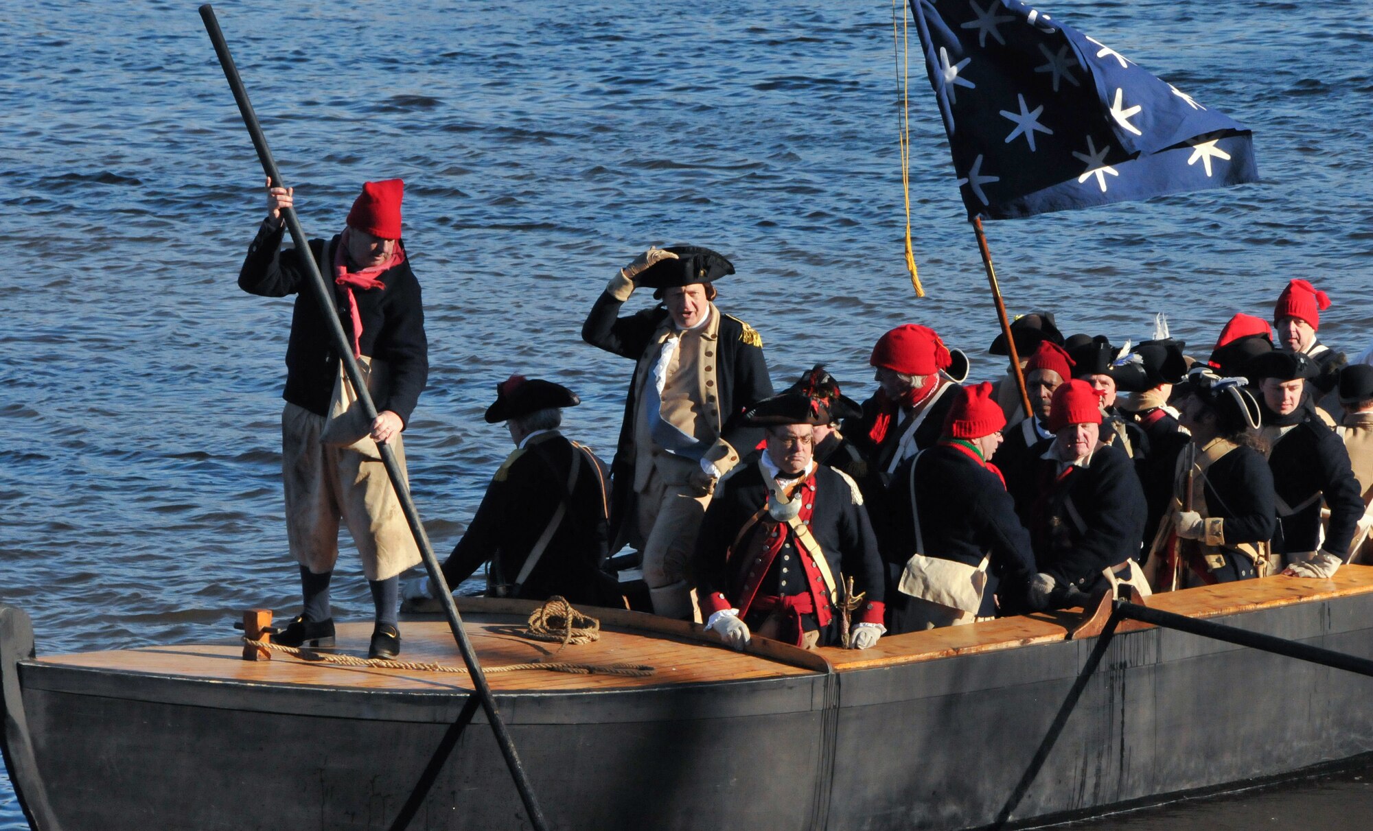 Gen. George Washington, as portrayed by a member of the Washington Crossing Re-enactors Society, guides his Durham boat across the Delaware River during the Dec. 7, 2014, dress rehearsal for the 62nd Annual Crossing of the Delaware re-enactment scheduled for Christmas day at Washington Crossing Historic Park, Pa. Each December, thousands of people gather on the New Jersey and Pennsylvania banks of the Delaware River to watch the re-enactment of George Washington's 1776 river crossing during the American Revolution. (U.S. Army Sgt. Salvatore Ottaviano/Released)