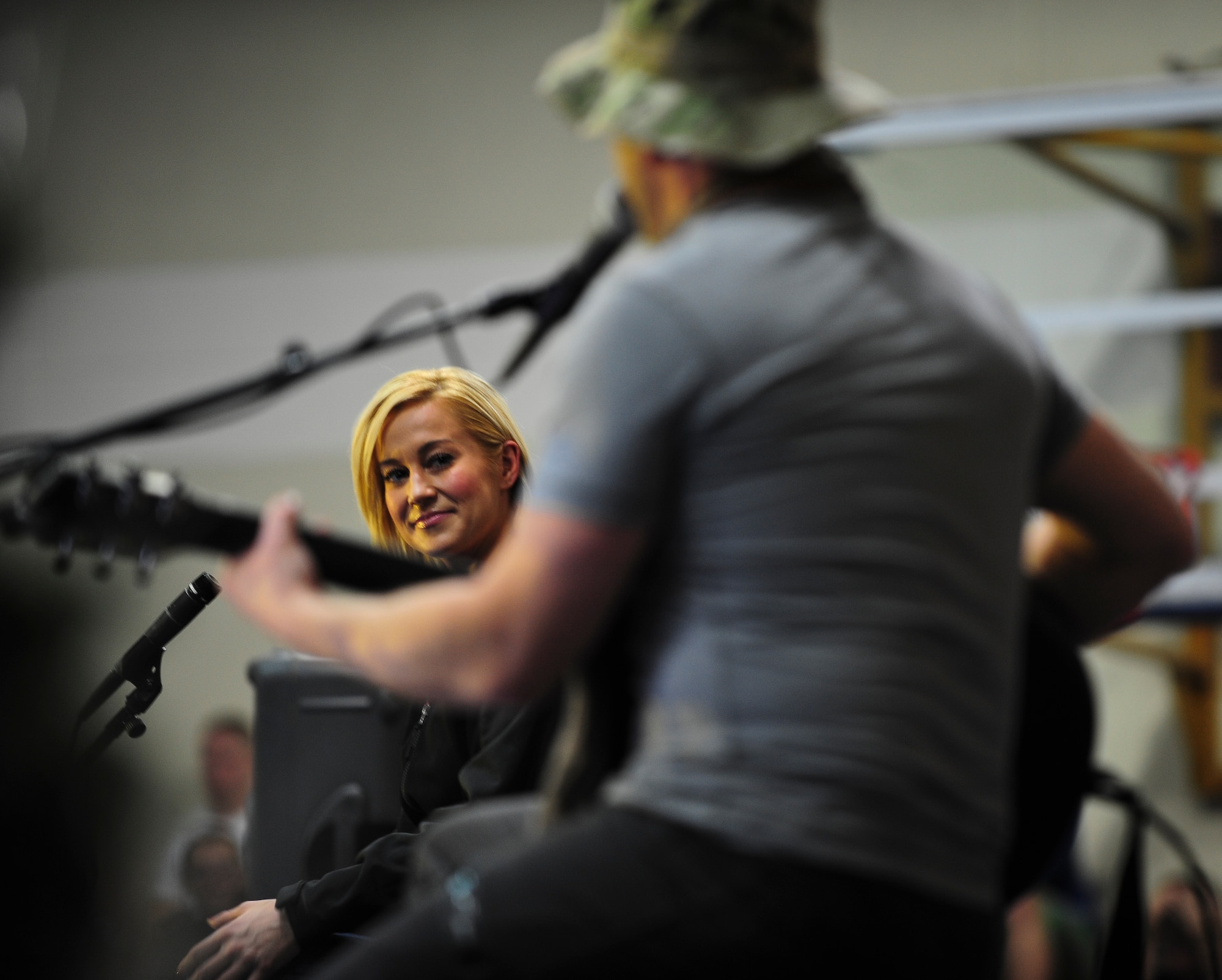 Country singer Kellie Pickler glances at her husband, Kyle Jacobs, while he performs during a United Service Organizations holiday tour Dec. 8, 2014, at Incirlik Air Base, Turkey. This trip will mark Pickler’s eighth USO tour. (U.S. Air Force photo by Airman Cory W. Bush/Released)