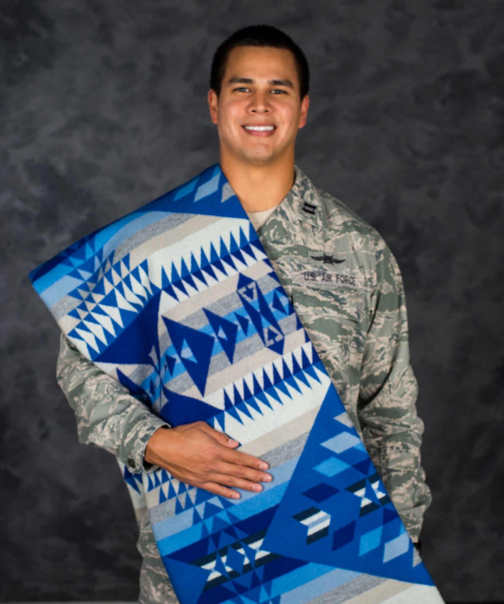 U.S. Air Force Capt. Myles Morales, 336th Recruiting Squadron support flight commander, poses for a photo with his pendleton quilt Dec. 3, 2014, at Moody Air Force Base, Ga. Morales’ native name is Wanbli Kinyan Gli and it translates to ‘the eagle flies home.’ (U.S. Air Force photo by Airman 1st Class Ceaira Tinsley/Released)