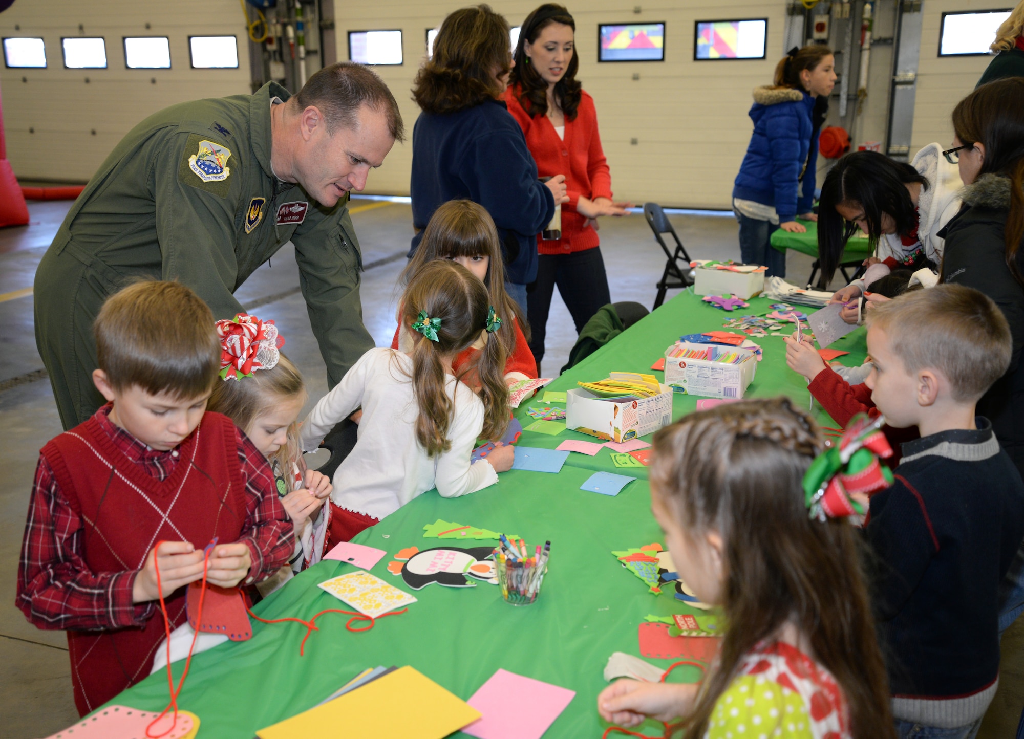 U.S. Air Force Col. Kenneth T. Bibb Jr., third from left, speaks to Team Mildenhall children during Breakfast with Santa Dec. 6, 2014, on RAF Mildenhall, England. Santa greeted the children after arriving in a fire truck with Team Mildenhall firefighters. (U.S. Air Force photo by Airman 1st Class Dillon Johnston/Released)