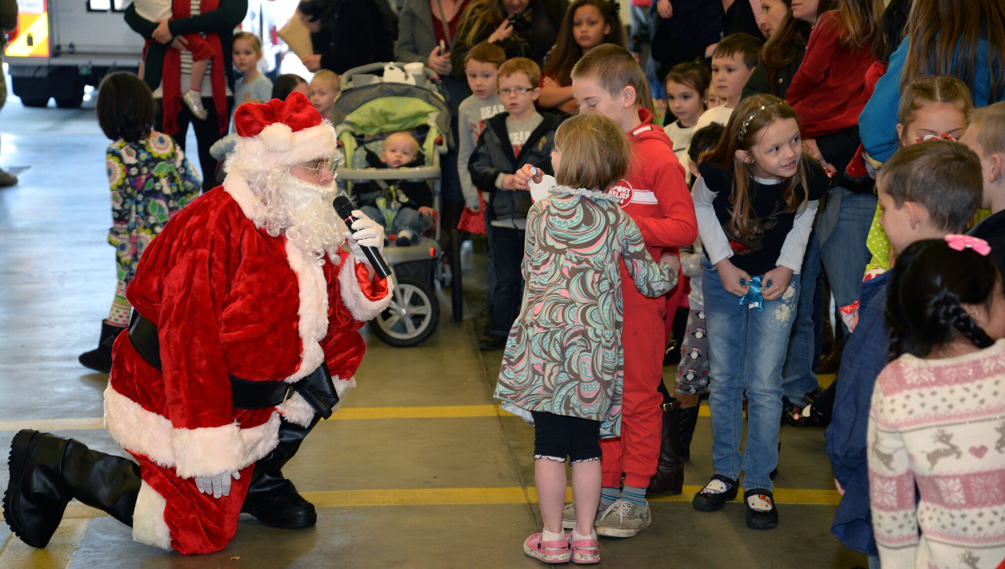 Santa speaks to Team Mildenhall children during Breakfast with Santa Dec. 6, 2014, on RAF Mildenhall, England. Santa greeted the children after arriving in a fire truck with Team Mildenhall firefighters. (U.S. Air Force photo by Airman 1st Class Dillon Johnston/Released)