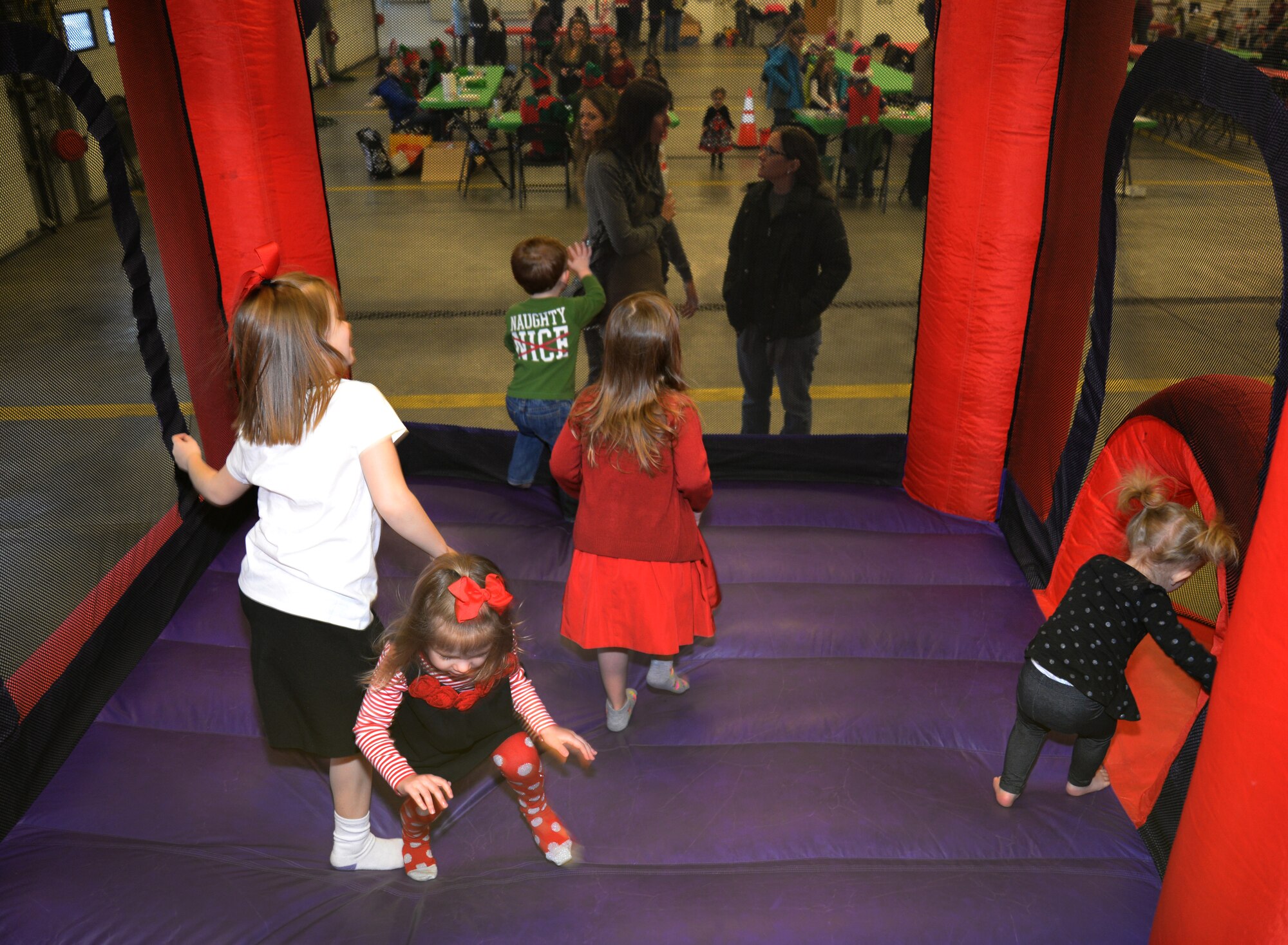 Team Mildenhall children play in a bouncy-house during Breakfast with Santa Dec. 6, 2014, on RAF Mildenhall, England. Arts and crafts, games and child friendly activities were offered during the event. (U.S. Air Force photo by Airman 1st Class Dillon Johnston/Released)