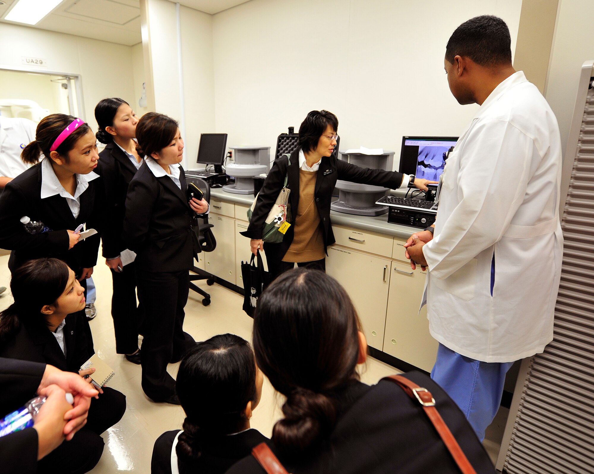 Yayoi Shikiya, Okinawa dental hygiene instructor, points at an X-ray of a mannequin's teeth during a tour of the dental clinic facility on Kadena Air Base, Japan, Dec. 5, 2014. Approximately 40 local dental hygiene students visited Kadena dental facility and toured periodontics, pedodontics, the Area Dental Lab, radiology, sterilization, and dental hygiene treatment rooms. The purpose of visit was to show each country's professional knowledge. (U.S. Air Force photo by Naoto Anazawa/Released)


