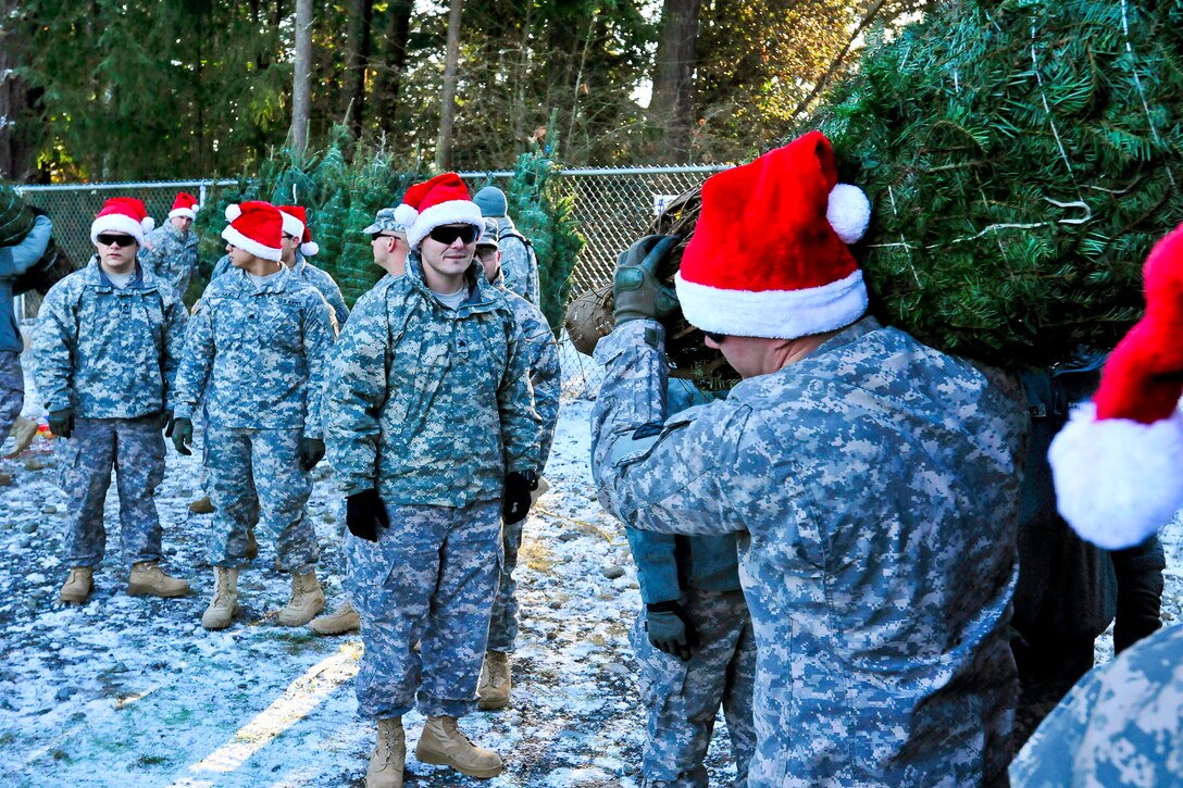 Soldiers work together to unload Christmas trees at the Northwest Adventure Center as part of the "Trees for Troops" program on Joint Base Lewis-McChord, Wash., Dec. 2, 2014. The soldiers are assigned to the I Corps, 7th Infantry Division's 17th Field Artillery Brigade. The Christmas Spirit Foundation partnered with FedEx and private donors provided more than 1,000 free Christmas trees to military families across area this year.