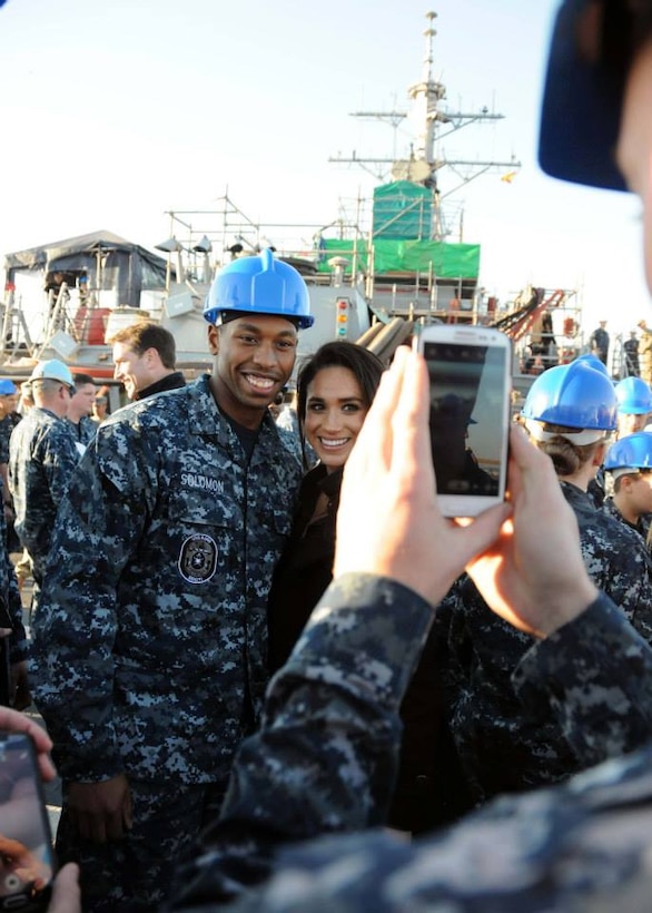 Meghan Markle, right, who has a leading role in the TV drama "Suits," poses with a sailor during a USO holiday visit on Naval Station Rota, Spain, Dec. 6, 2014. 