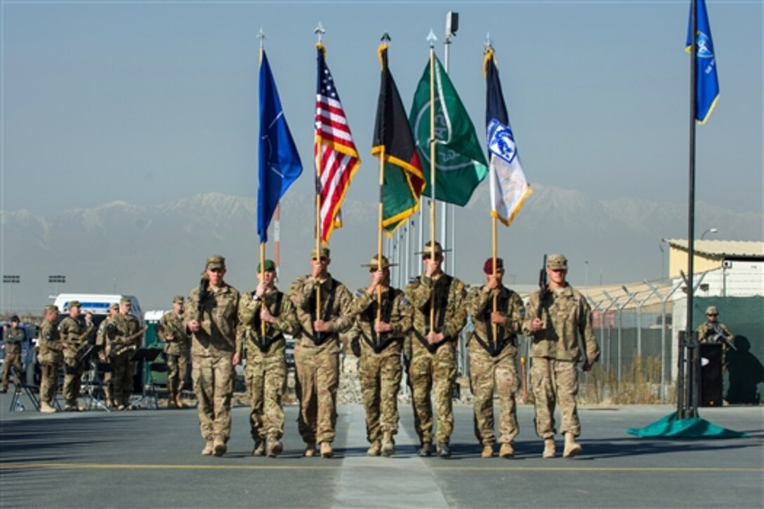 The International Security Assistance Force Joint Command color guard marches during an end-of-mission ceremony at Kabul International Airport in Afghanistan, Dec. 8, 2014.