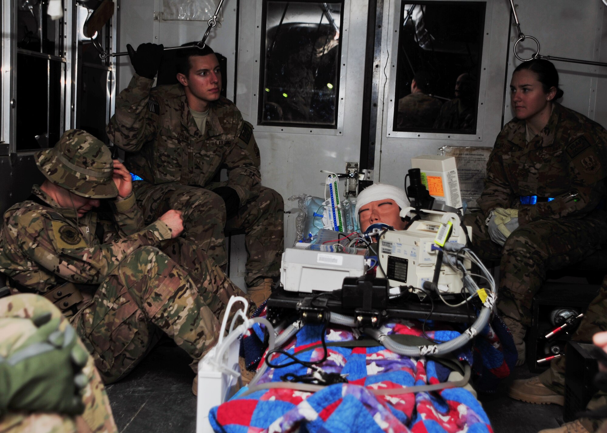 U.S. Air Force Airmen assigned to the 455th Expeditionary Medical Group’s Contingency Aeromedical Staging Facility sit with a simulated patient during a training scenario Dec. 6, 2014 at Bagram Airfield, Afghanistan. The scenario was designed to refine skills, communication and streamline critical transport processes. (U.S. Air Force photo by Staff Sgt. Whitney Amstutz/released)