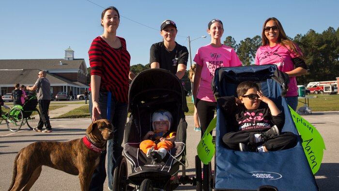 The recipients of new push chairs, Little Geronime (left) and Aaron (right), sit surrounded by their mothers and angels from Eastern Carolina’s chapter of Ainsley’s Angels of America during Midway Park Community Center’s Great Pumpkin Haul Fun Run, Saturday. Members of Ainsley’s Angels, a nonprofit group dedicated to bringing the thrill of athletic events to disabled and special needs members of the community, raised money and donated the chairs to the families.