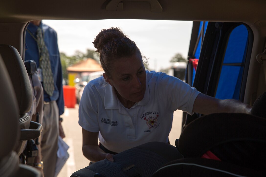 Susanna Williams, training division chief with Jacksonville Fire and Emergency Services, inspects a car seat at Base Safety Division’s quarterly Child Passenger Safety Seat Check at the parking lot of the Marine Corps Exchange aboard Marine Corps Base Camp Lejeune, May 19 to 21. Representatives certified by the National Highway Traffic Safety Administration, including members of Jacksonville’s Fire and Emergency Services, Onslow County Sheriff's Office, N.C. State Highway Patrol, the Provost Marshal’s Office and the Base Safety Division, conducted the checks.