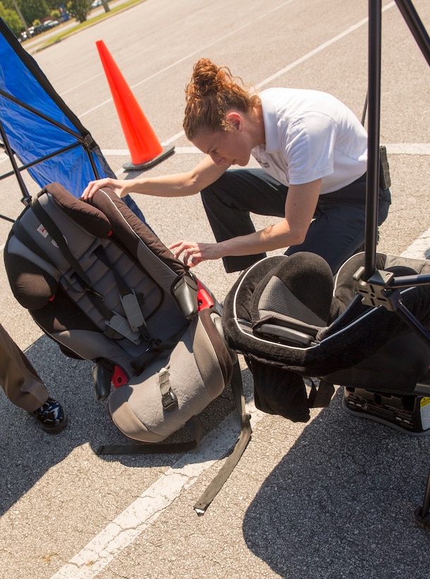 Susanna Williams, training division chief with Jacksonville Fire and Emergency Services, inspects a car seat at Base Safety Division’s quarterly Child Passenger Safety Seat Check at the parking lot of the Marine Corps Exchange aboard Marine Corps Base Camp Lejeune, May 19 to 21. Representatives certified by the National Highway Traffic Safety Administration, including members of Jacksonville’s Fire and Emergency Services, Onslow County Sheriff's Office, N.C. State Highway Patrol, the Provost Marshal’s Office and the Base Safety Division, conducted the checks.