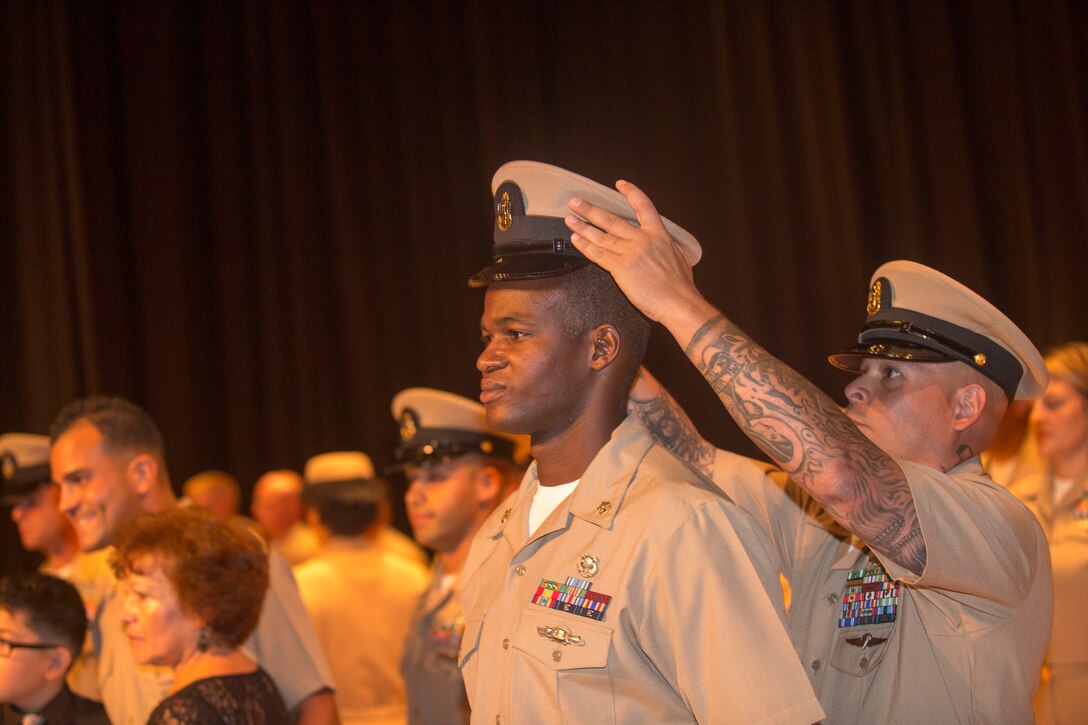 Chief Petty Officer Adrian Figueroa places a cover on new Chief Petty Officer Clarence Allen during his induction ceremony, at the base theater aboard the Marine Corps Base Camp Lejeune, September 16. Twenty-two sailors from area units earned the promotion to E-7 after undergoing testing, a selection board and a six-week induction program.