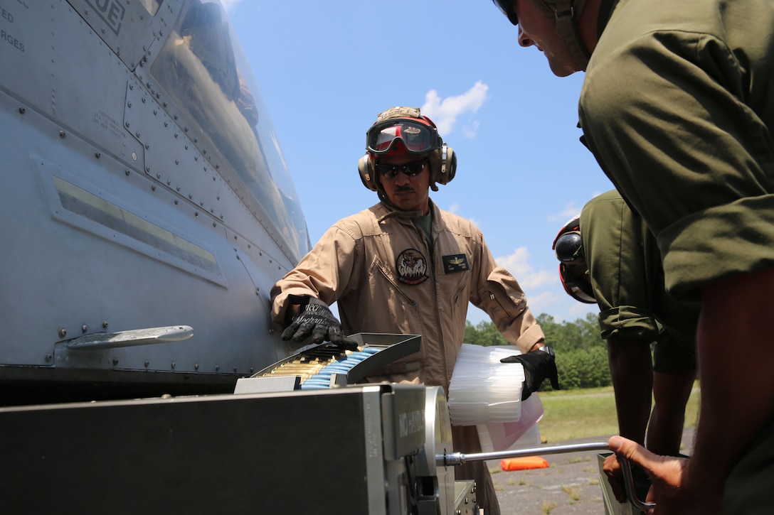 Gunnery Sgt. Andre Duplessis, an aviation ordnance chief with Marine Light Attack Helicopter Squadron 269 from Hesperia, Calif., feeds rounds into an AH-1W Super Cobra helicopter during Forward Arming and Refueling Point exercises at Marine Corps Outlying Field Camp Davis, near Holly Ridge, N.C., July 8. Throughout the week the Marines with HLMA-269 filled and reloaded aircraft 18 times with 200 to 300 gallons of fuel each time.