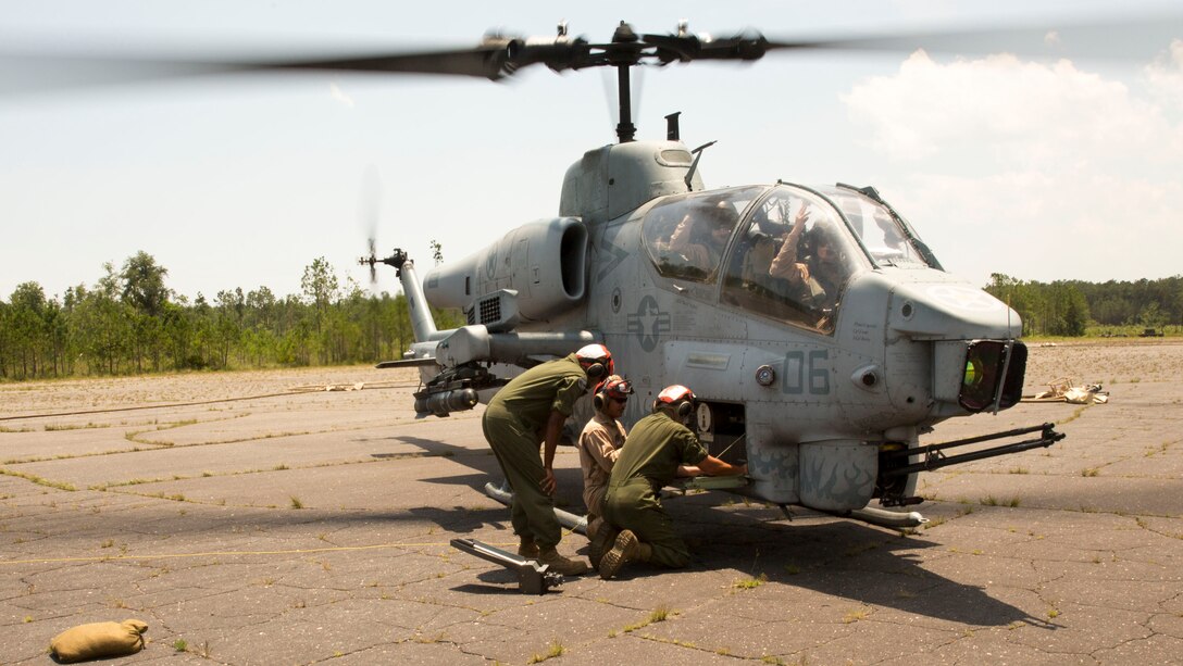 Aviation ordnance Marines with Marine Light Attack Helicopter Squadron 269 from Hesperia, Calif., inspect an AH-1W Super Cobra helicopter during Forward Arming and Refueling Point exercises at Marine Corps Outlying Field Camp Davis, near Holly Ridge, N.C., July 8. Throughout the week the Marines with HLMA-269 filled and reloaded aircraft 18 times with 200 to 300 gallons of fuel each time.