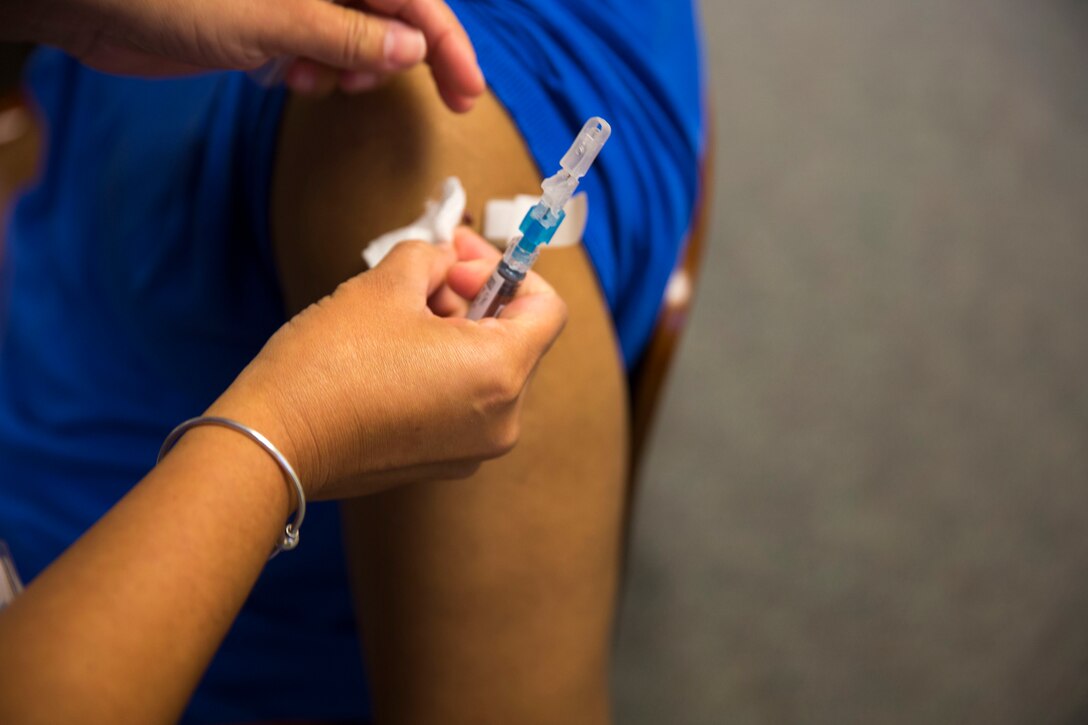 A healthcare professional puts a band aid over the site of an injection after providing a flu vaccine to a patient during a Community influenza vaccination event held by Naval Hospital Camp Lejeune aboard Marine Corps Base Camp Lejeune, Oct. 20. Everyone 6 months of age and older should get a flu vaccine each year, said Lt. Cmdr. Bryan Alvarez, Naval Hospital Camp Lejeune’s director of Public Health. 