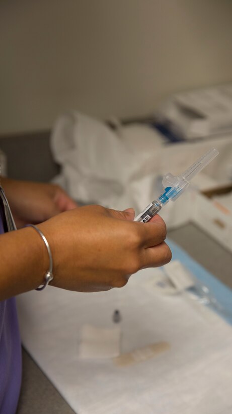 A healthcare professional prepares a flu vaccine during a Community influenza vaccination event held by Naval Hospital Camp Lejeune aboard Marine Corps Base Camp Lejeune, Oct. 20. Everyone 6 months of age and older should get a flu vaccine each year, said Lt. Cmdr. Bryan Alvarez, Naval Hospital Camp Lejeune’s director of Public Health. 