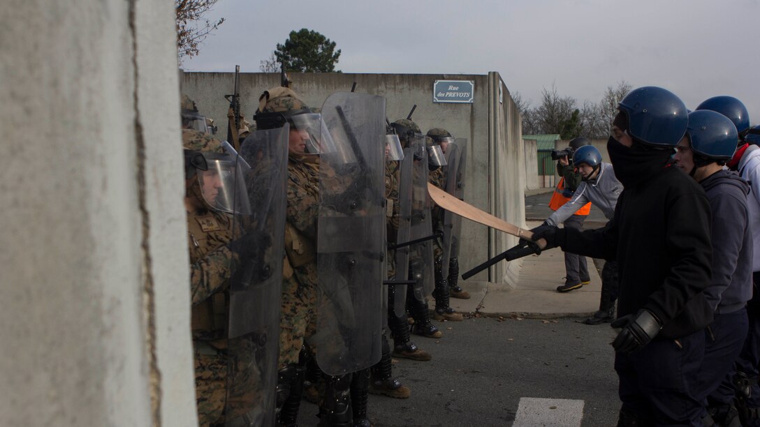 U.S. Marines with SPMAGTF Crisis Response – Africa are taunted by role-playing rioters during crowd and riot control techniques training at the National Gendarmerie Training Center in St. Astier, France, Dec. 3, 2014. The exercise allowed the Marines to gain greater knowledge of non-lethal tactics, techniques and procedures while enhancing interoperability with the French Gendarmerie and strengthening the U.S. partnership with France. 