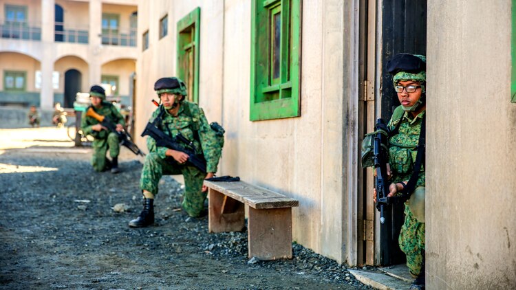 Soldiers with 7th Singapore Infantry Brigade post security during a patrol in a simulated combat town as part of exercise Valiant Mark aboard Marine Corps Base, Camp Pendleton, Dec. 6, 2014. Valiant Mark enhances U.S. and Singapore forces combined combat readiness through live-fire and urban terrain training as well as amphibious operations familiarization. (U.S. Marine Corps photo by Lance Cpl. Danielle Rodrigues)